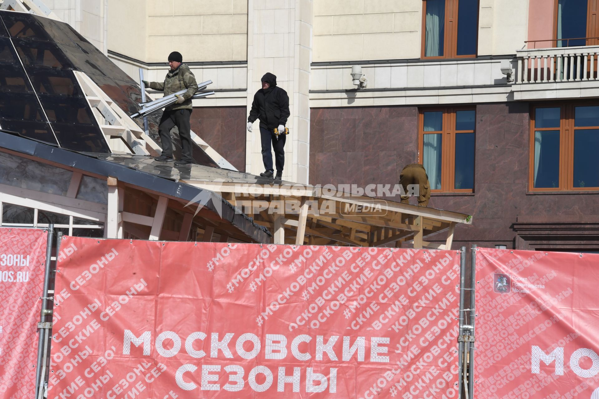 Москва.  Рабочие разбирают конструкции.