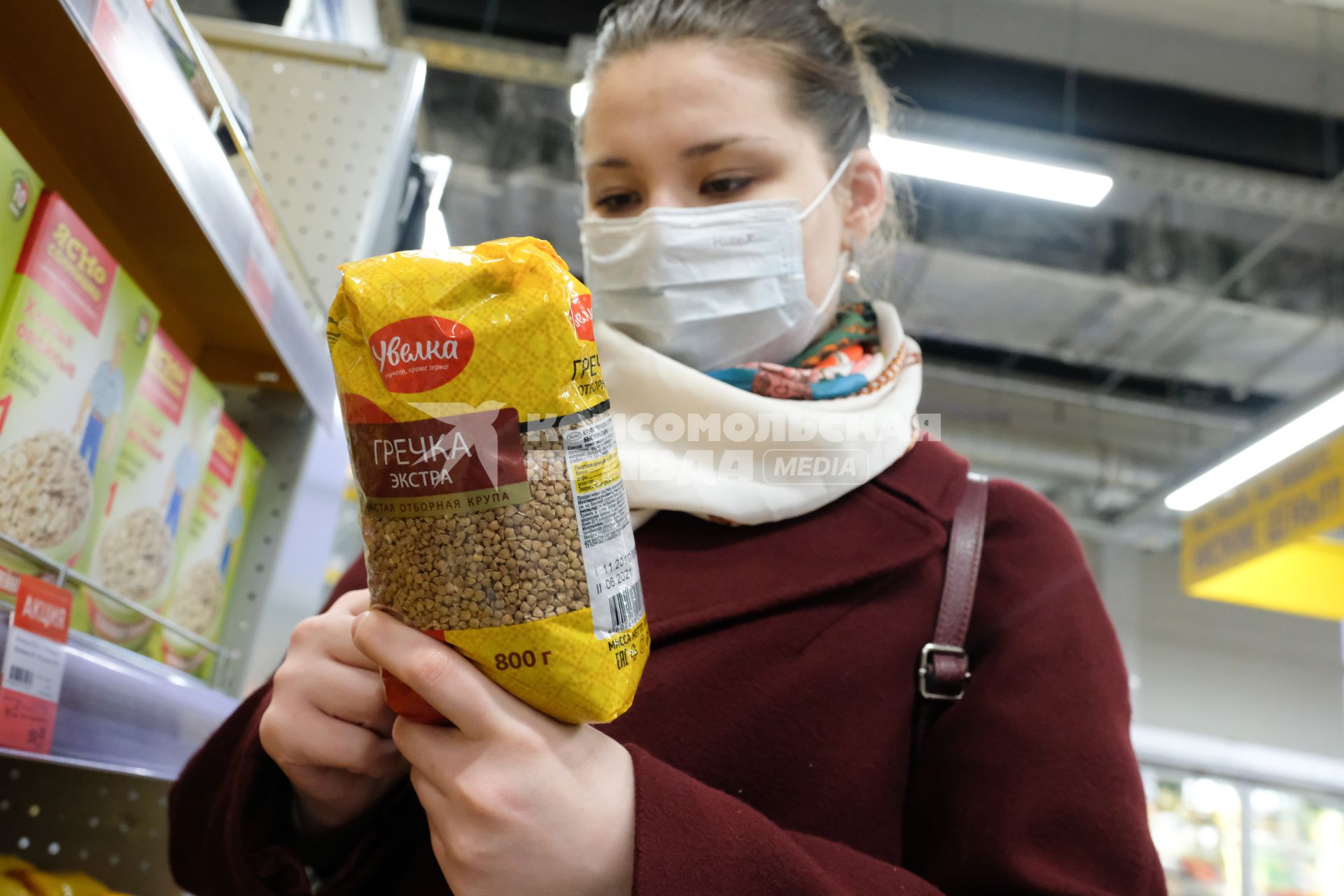 Санкт-Петербург. Покупательница в медицинской маске  в магазине  у полок с товаром.