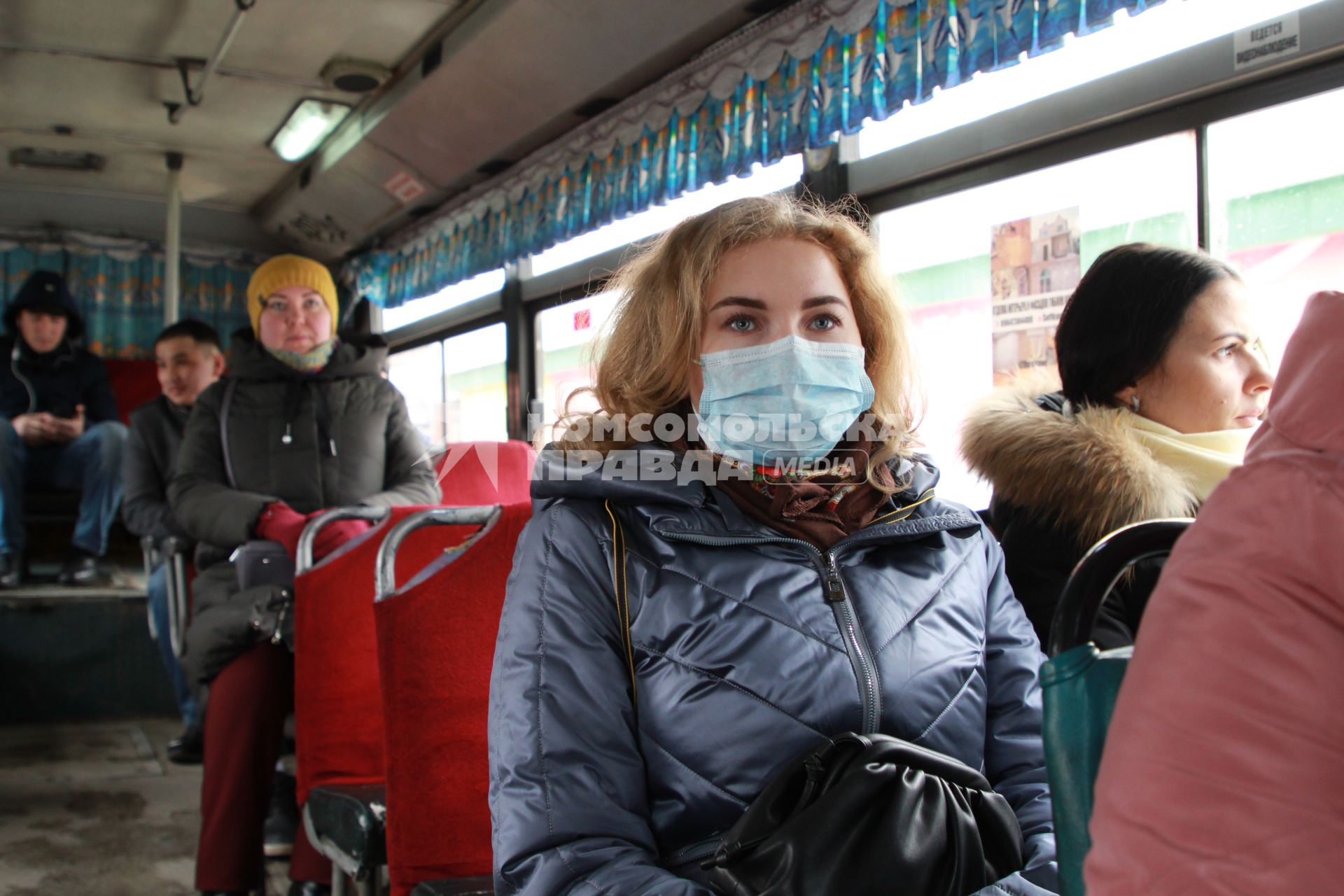 Иркутск. Девушка в медицинской маске едет в общественном транспорте.