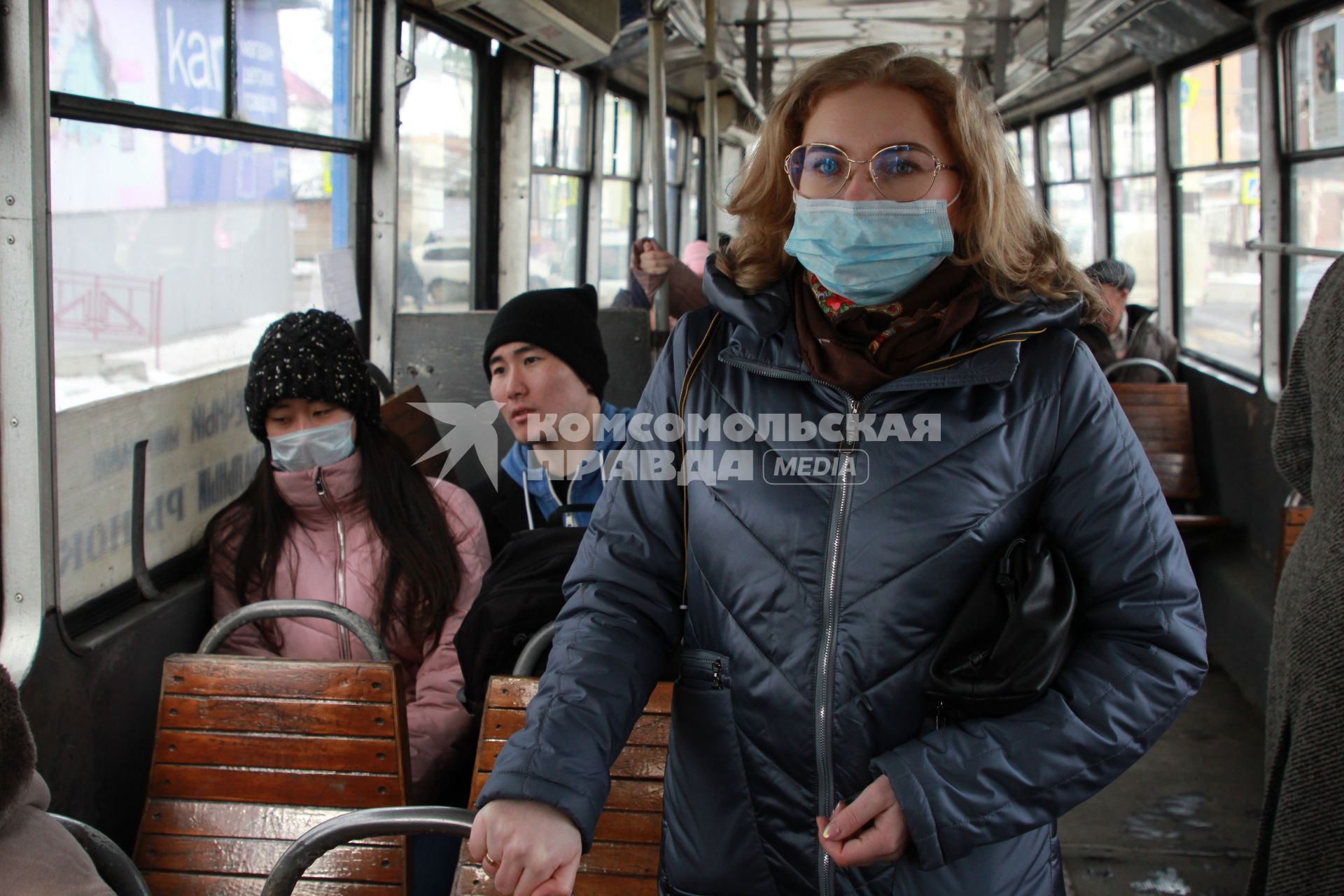 Иркутск. Девушка в медицинской маске едет в общественном транспорте.