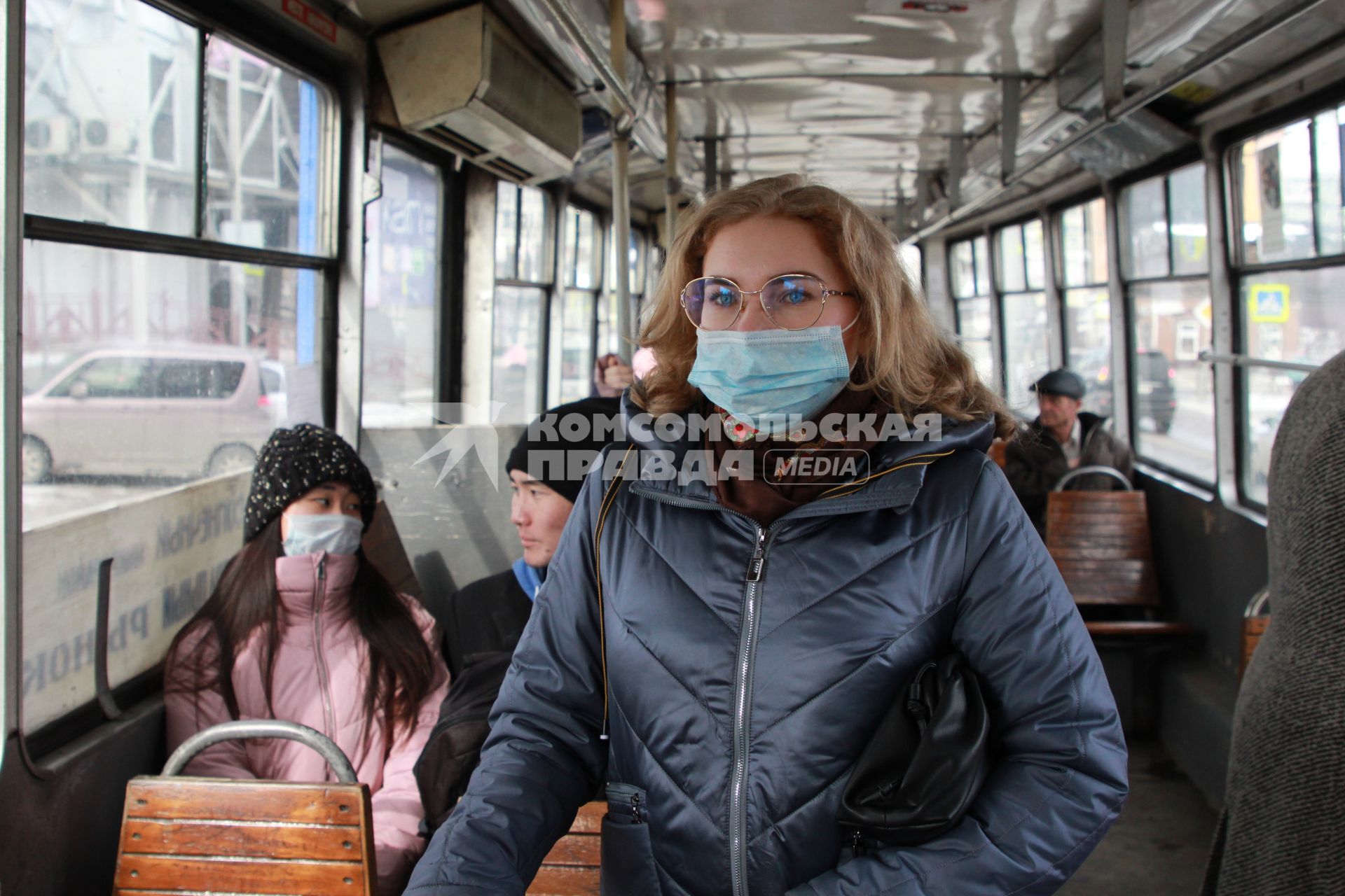 Иркутск. Девушка в медицинской маске едет в общественном транспорте.