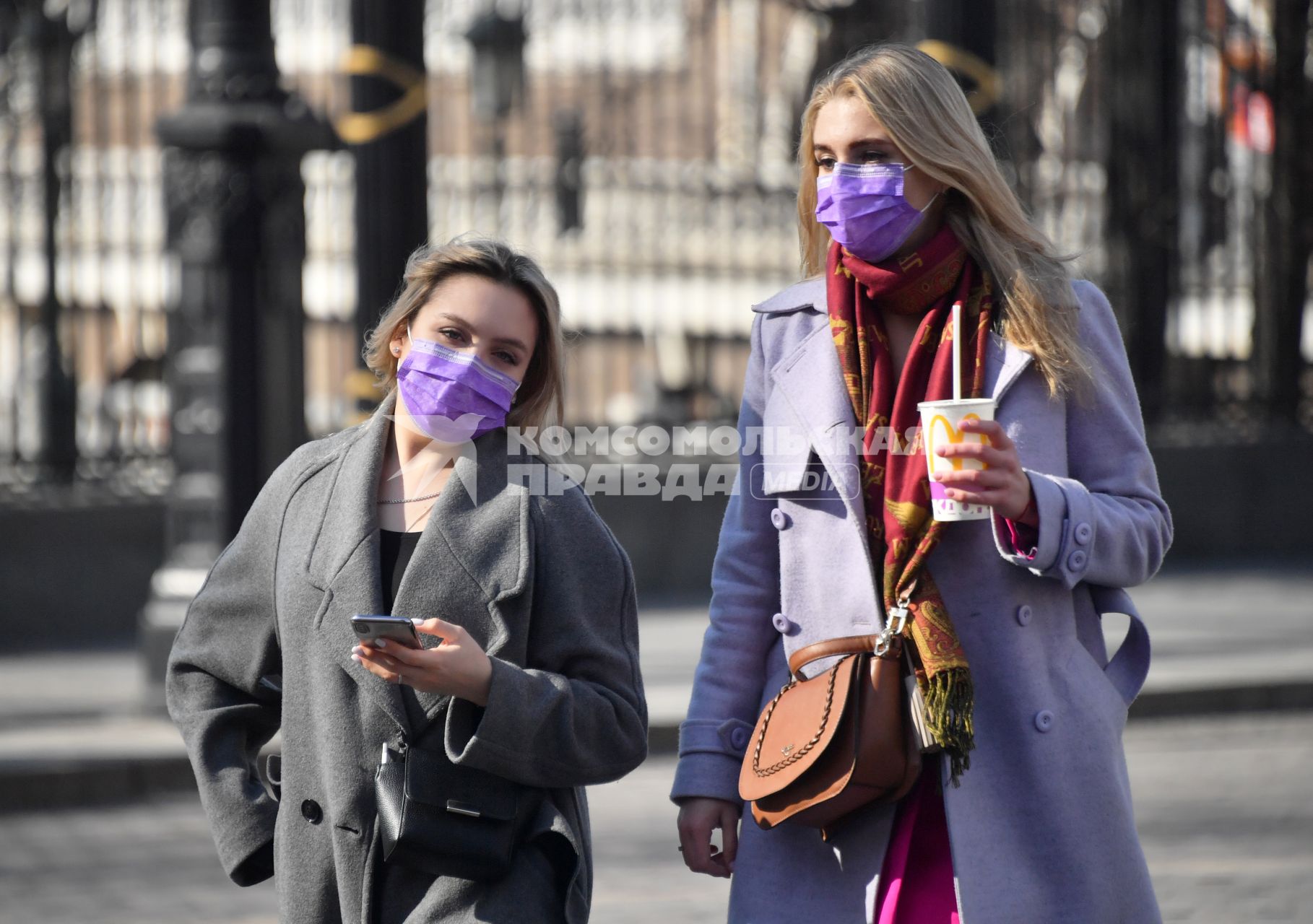 Москва.   Девушки в медицинских масках у Александровского сада.