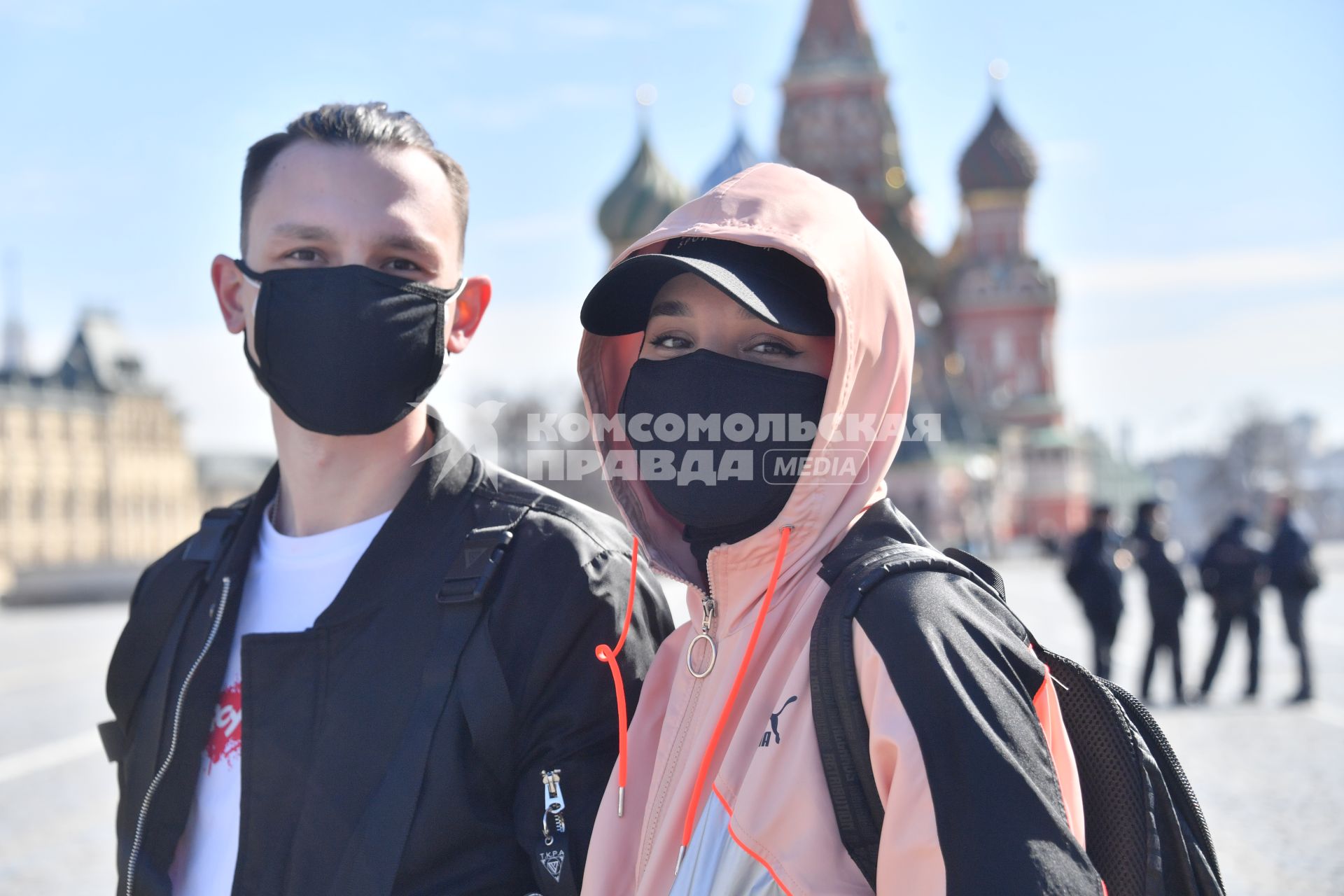 Москва.   Молодые люди в медицинских масках на Красной площади.