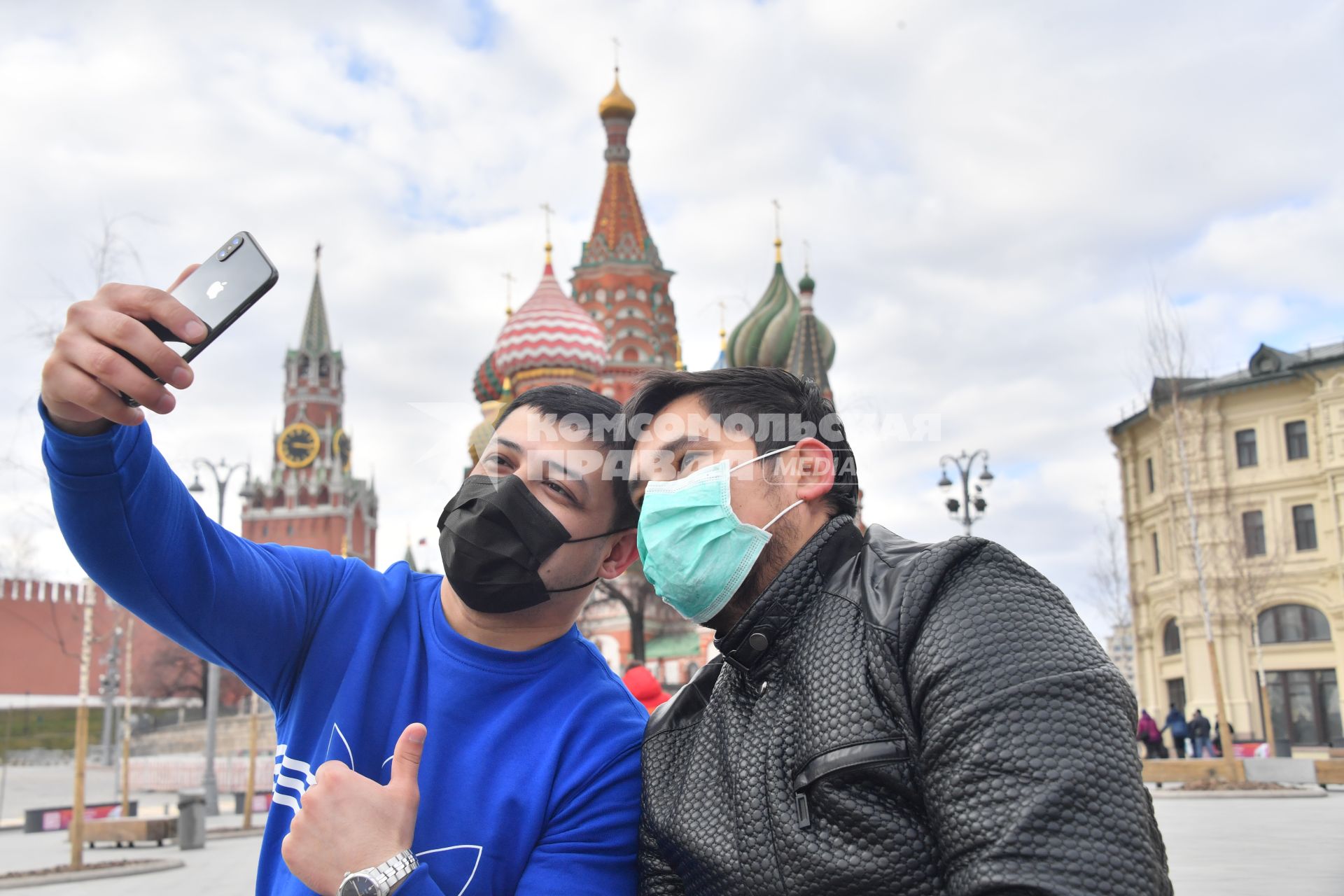 Москва.  Молодые люди в медицинских масках фотографируются у храма Василия Блаженного.