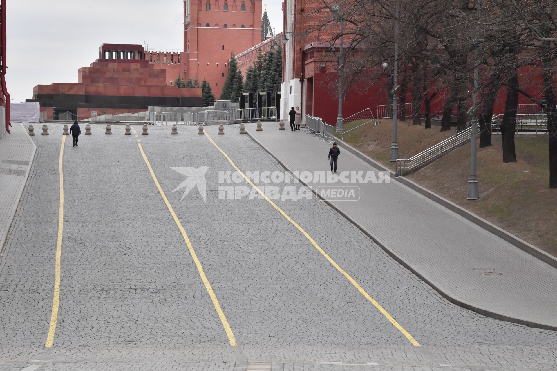 Москва.   Одиночные прохожие в Кремлевском проезде.