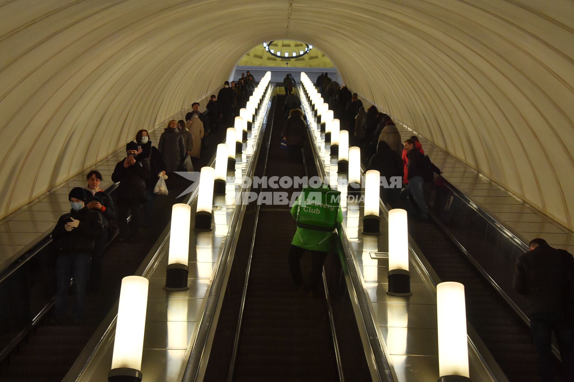 Москва.   Сотрудник сервиса по доставке еды `Деливери клаб` на эскалаторе московского метрополитена.