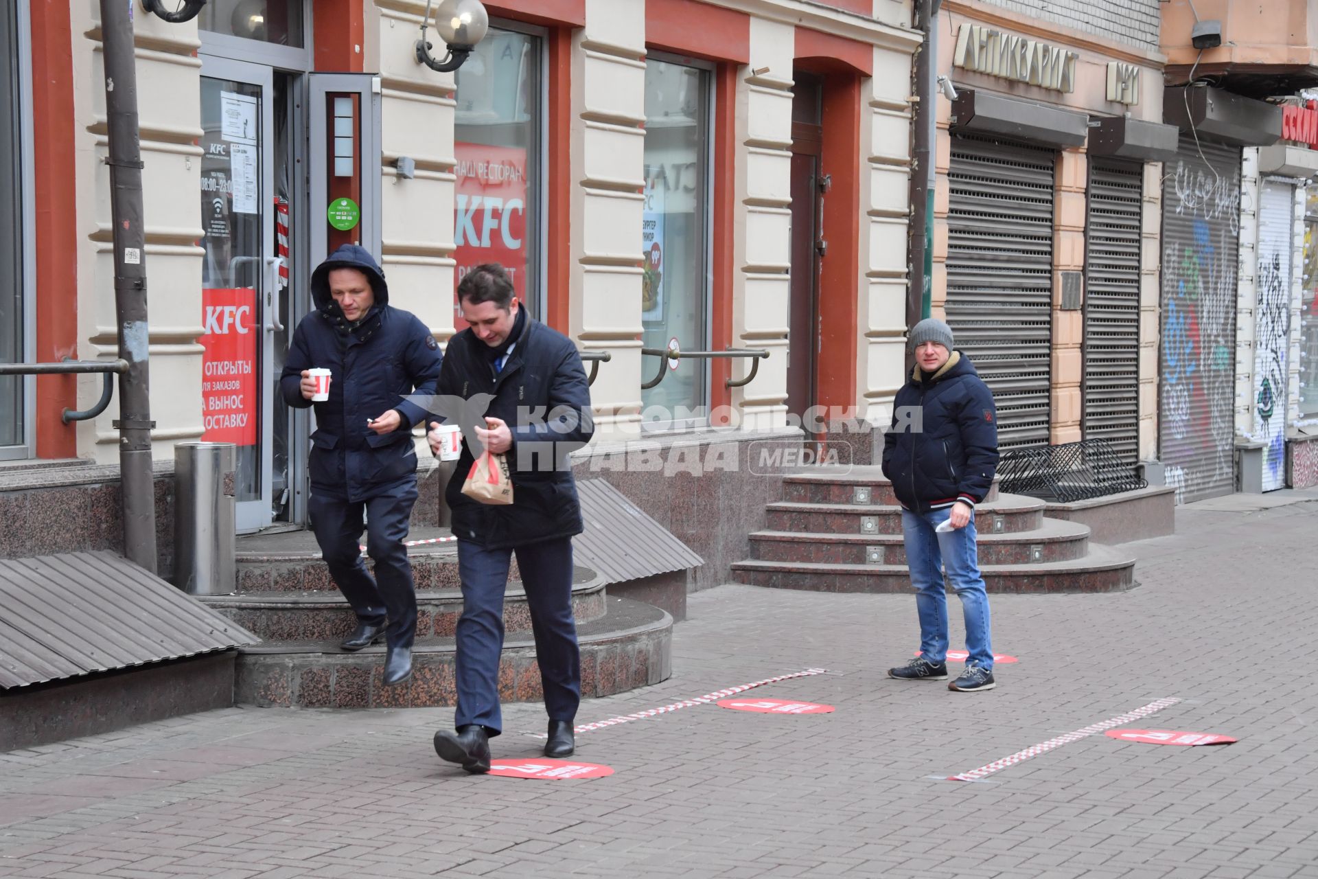 Москва.   Мужчины выходят из кафе KFC на Старом Арбате.