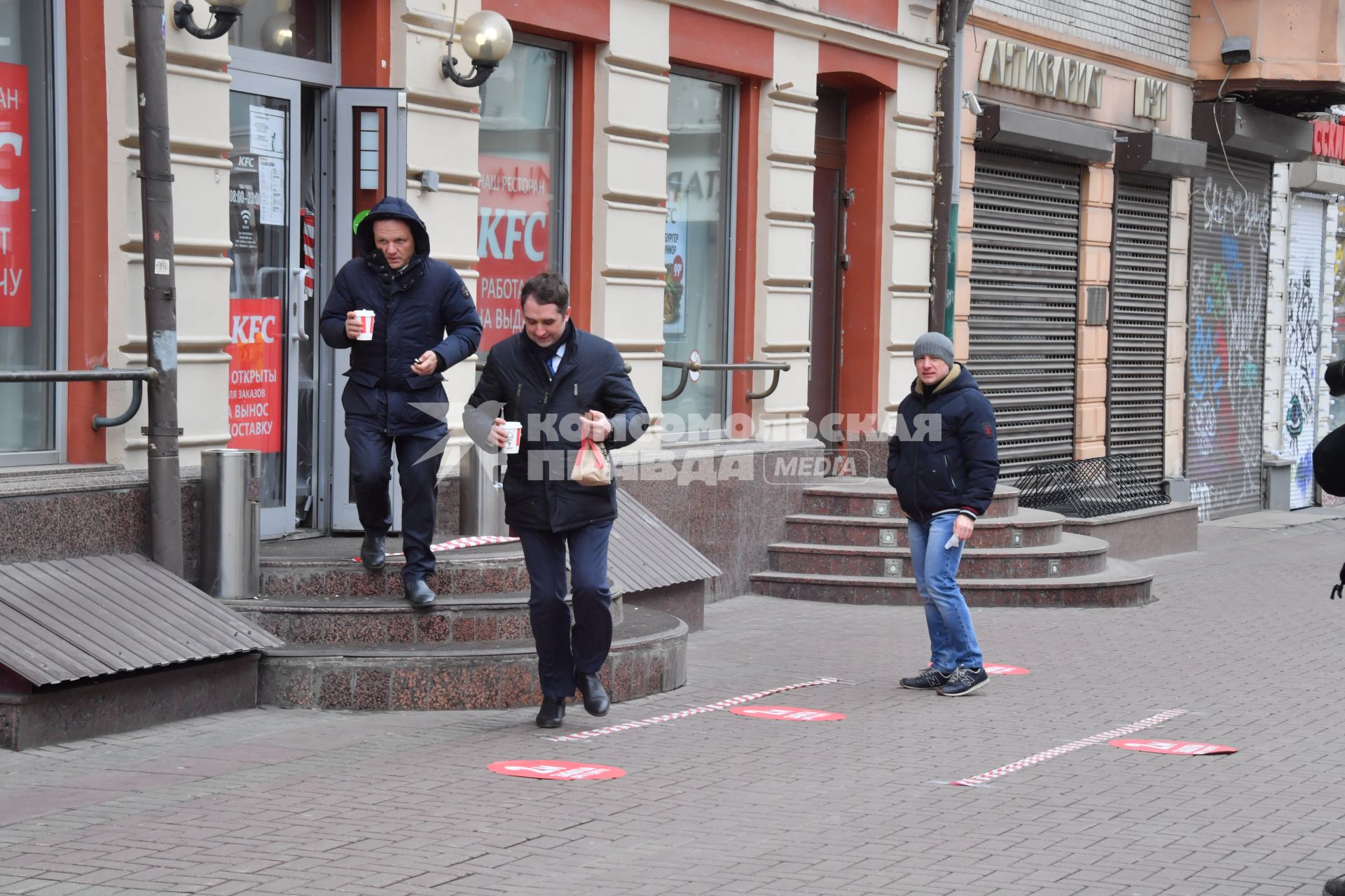 Москва.   Мужчины выходят из кафе KFC на Старом Арбате.