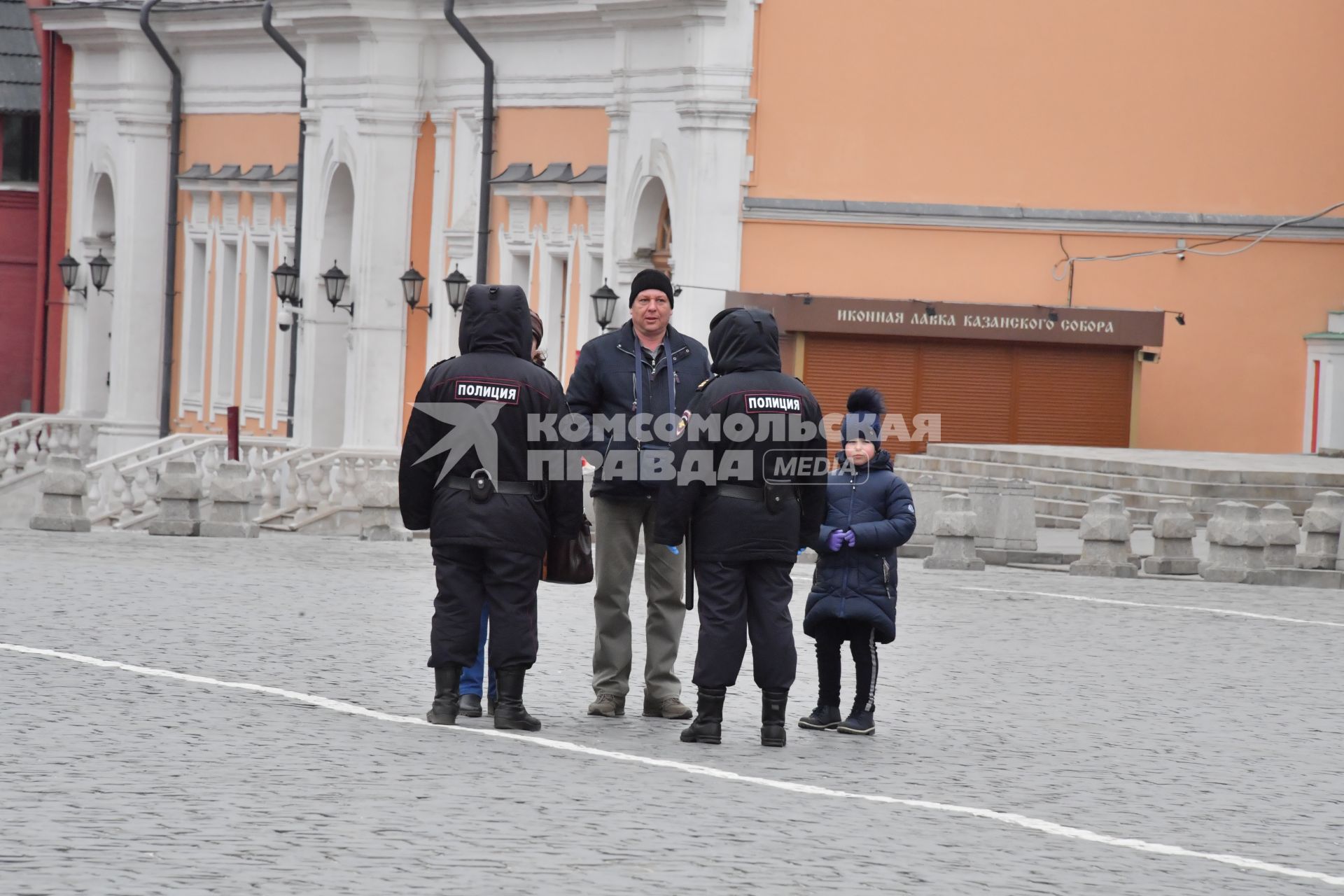 Москва.  Сотрудники полиции разговаривают  с мужчиной на красной площади.