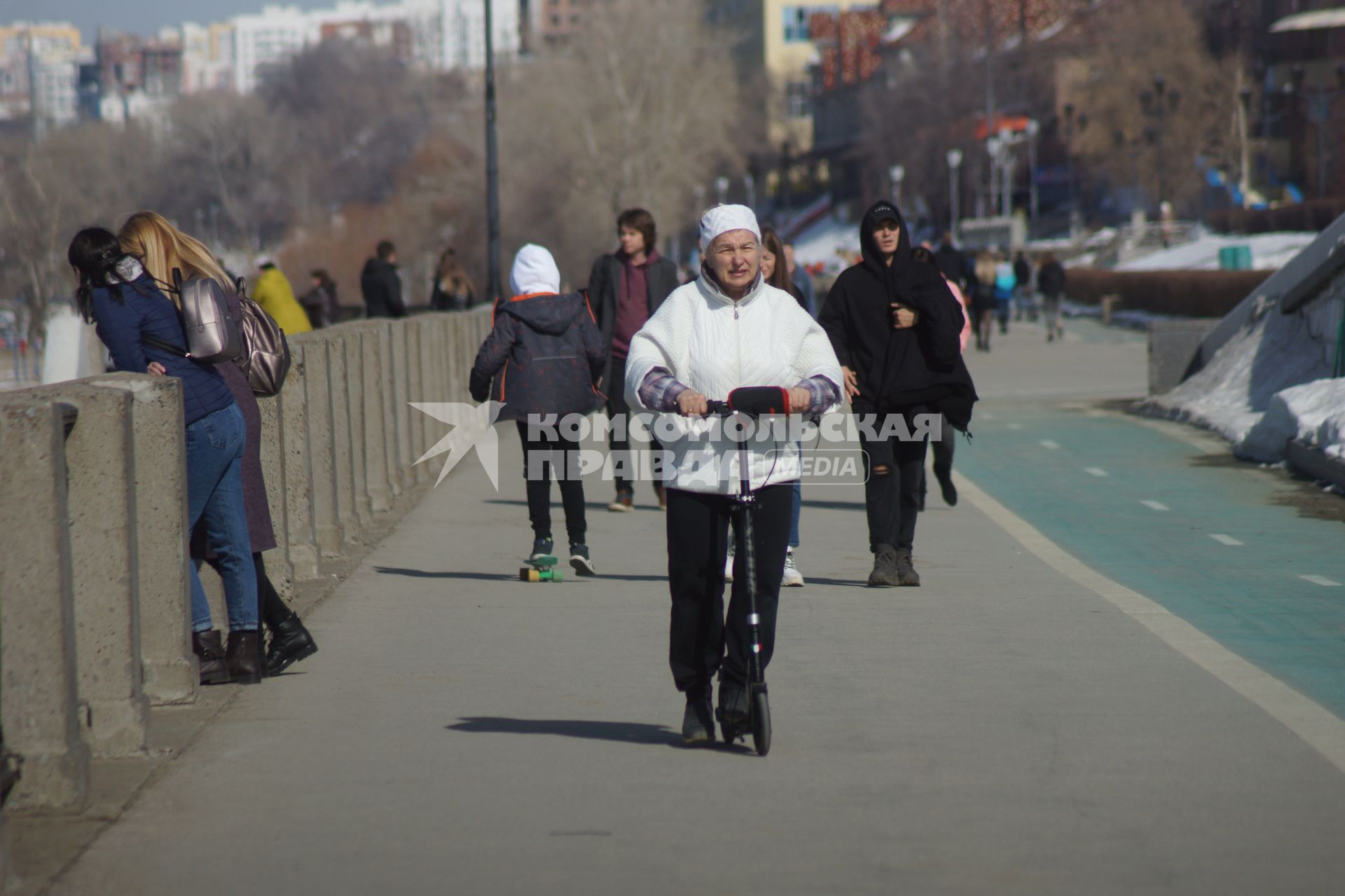 Самара.  Женщина на самокате на улице города.