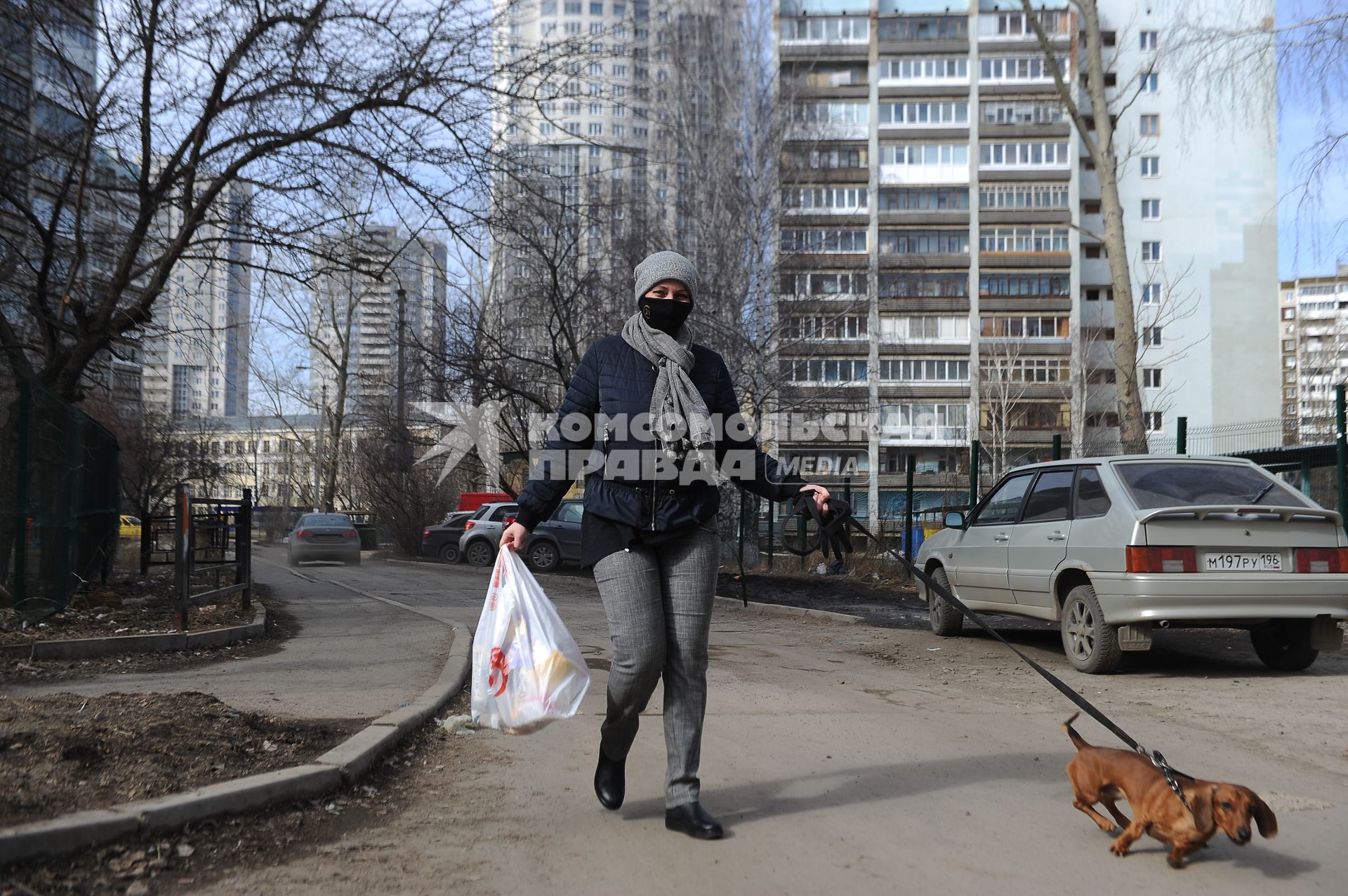 Екатеринбург. Женщина в медицинской маске гуляет с собакой во время нерабочей недели объявленной президентом РФ для снижения темпов распространения коронавируса COVID-19