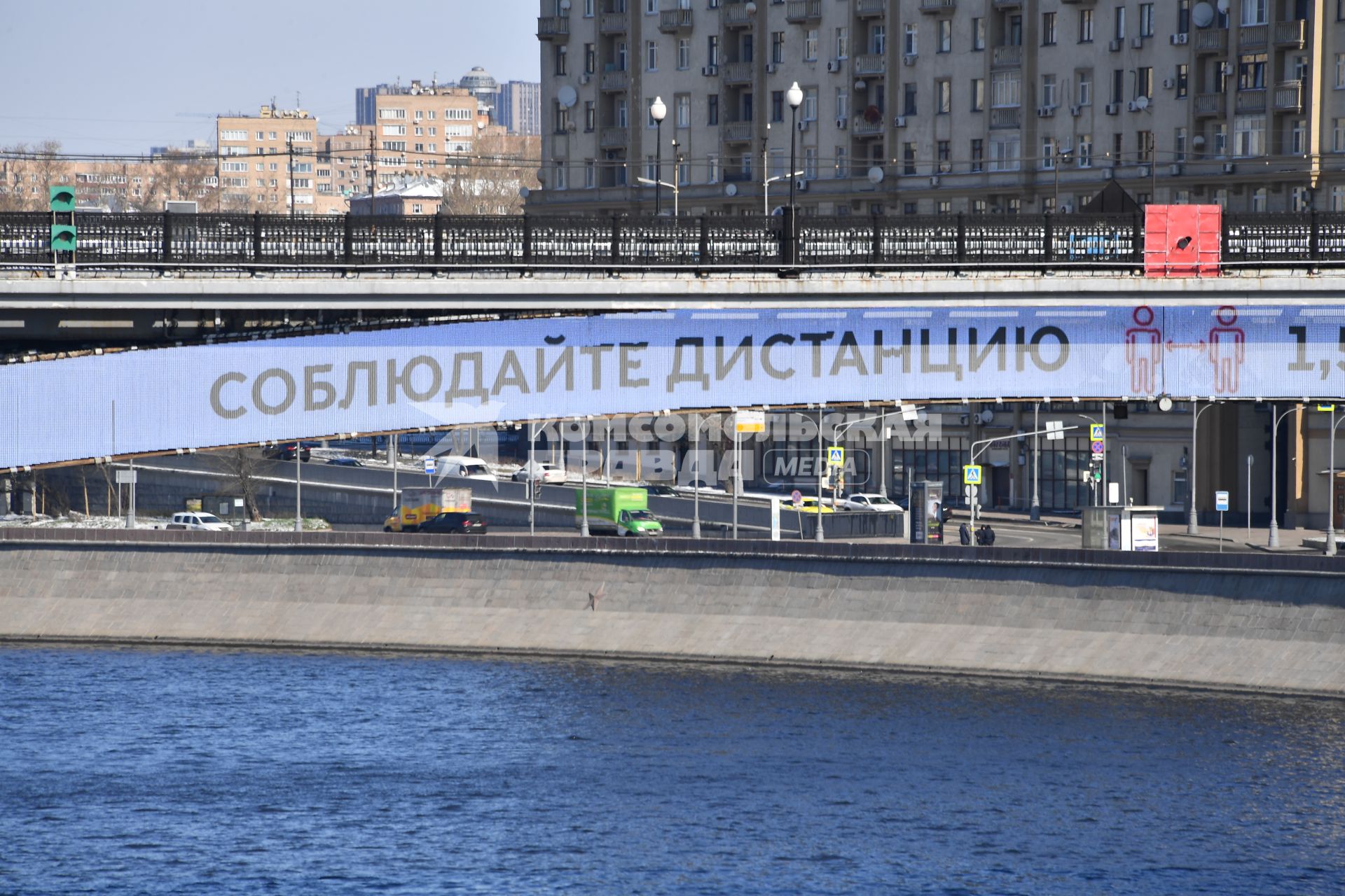 Москва.  Плакат с призывом соблюдать дистанцию от окружающих на Смоленском метромосту.