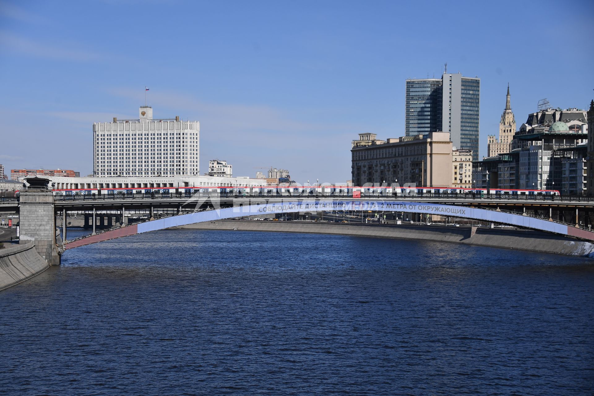 Москва.  Плакат с призывом соблюдать дистанцию от окружающих на Смоленском метромосту.