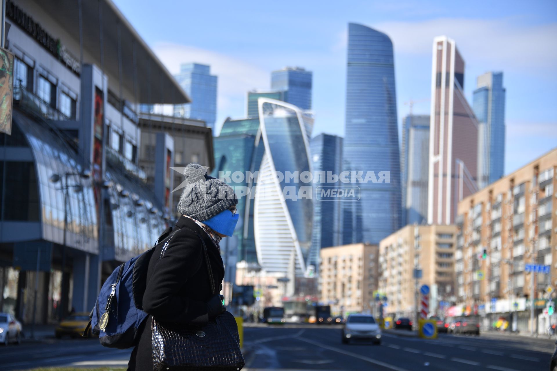 Москва.  Женщина в медицинской маске на улице города.