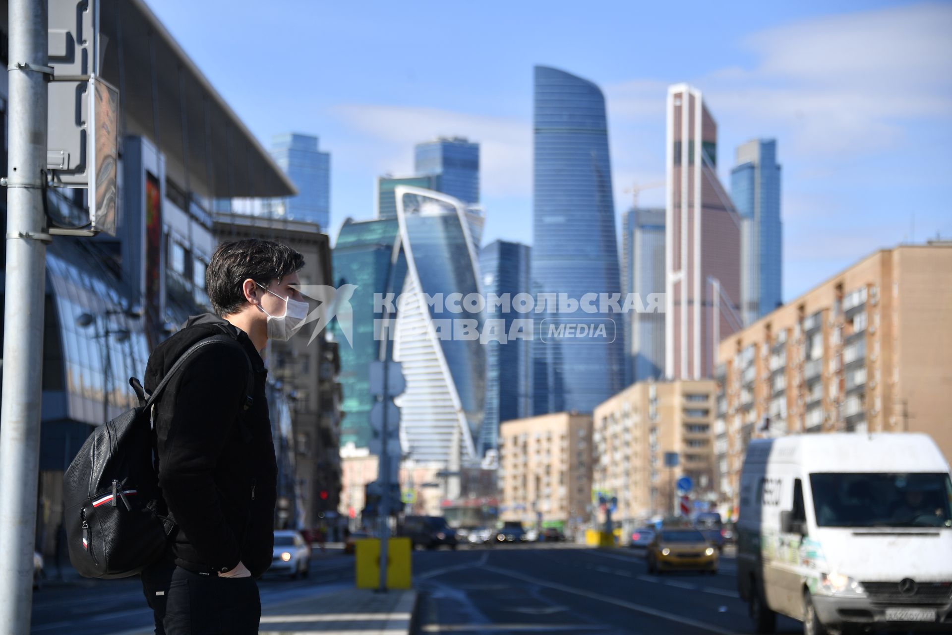 Москва.  Молодой человек в медицинской маске на улице города.