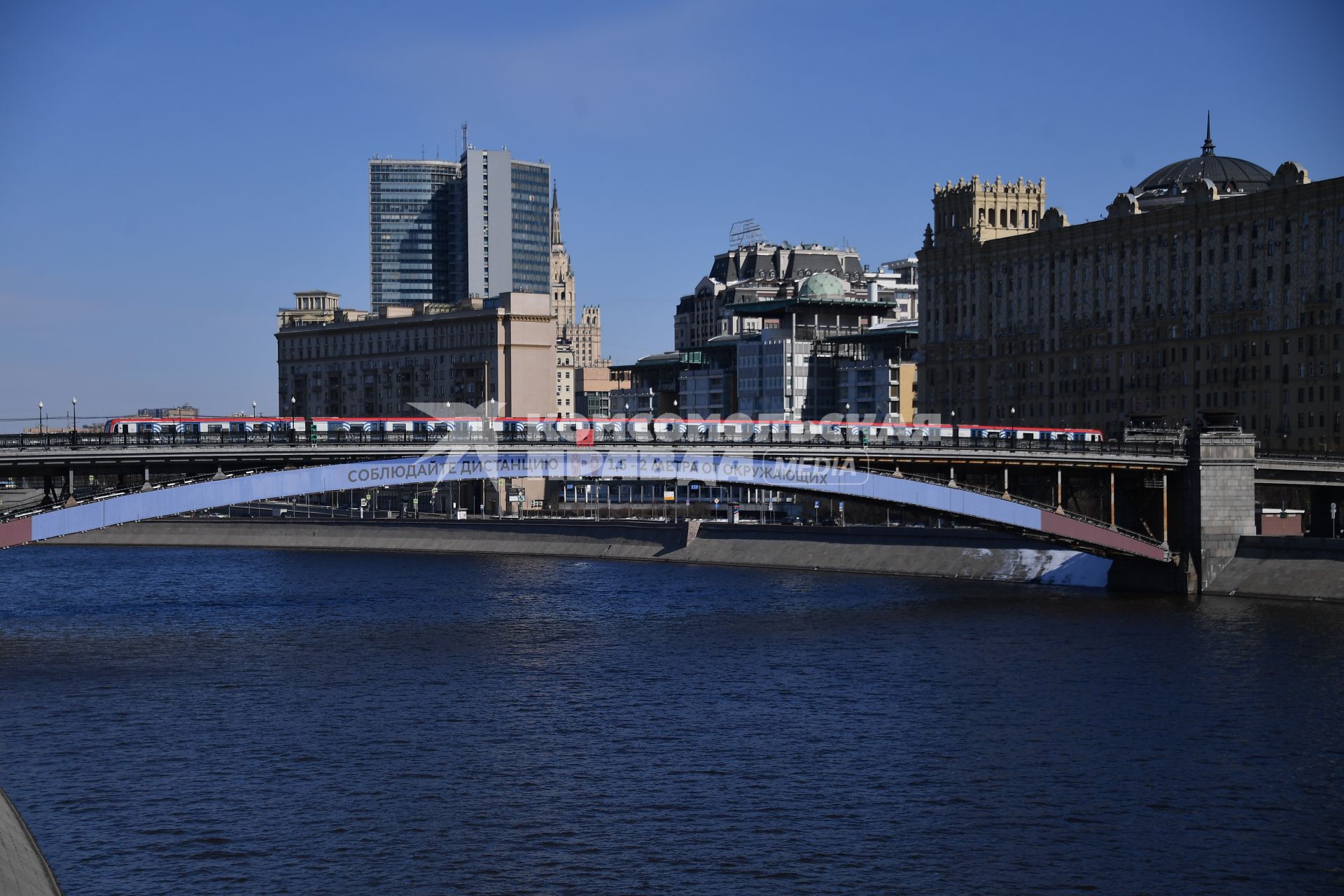 Москва.  Плакат с призывом соблюдать дистанцию от окружающих на Смоленском метромосту.