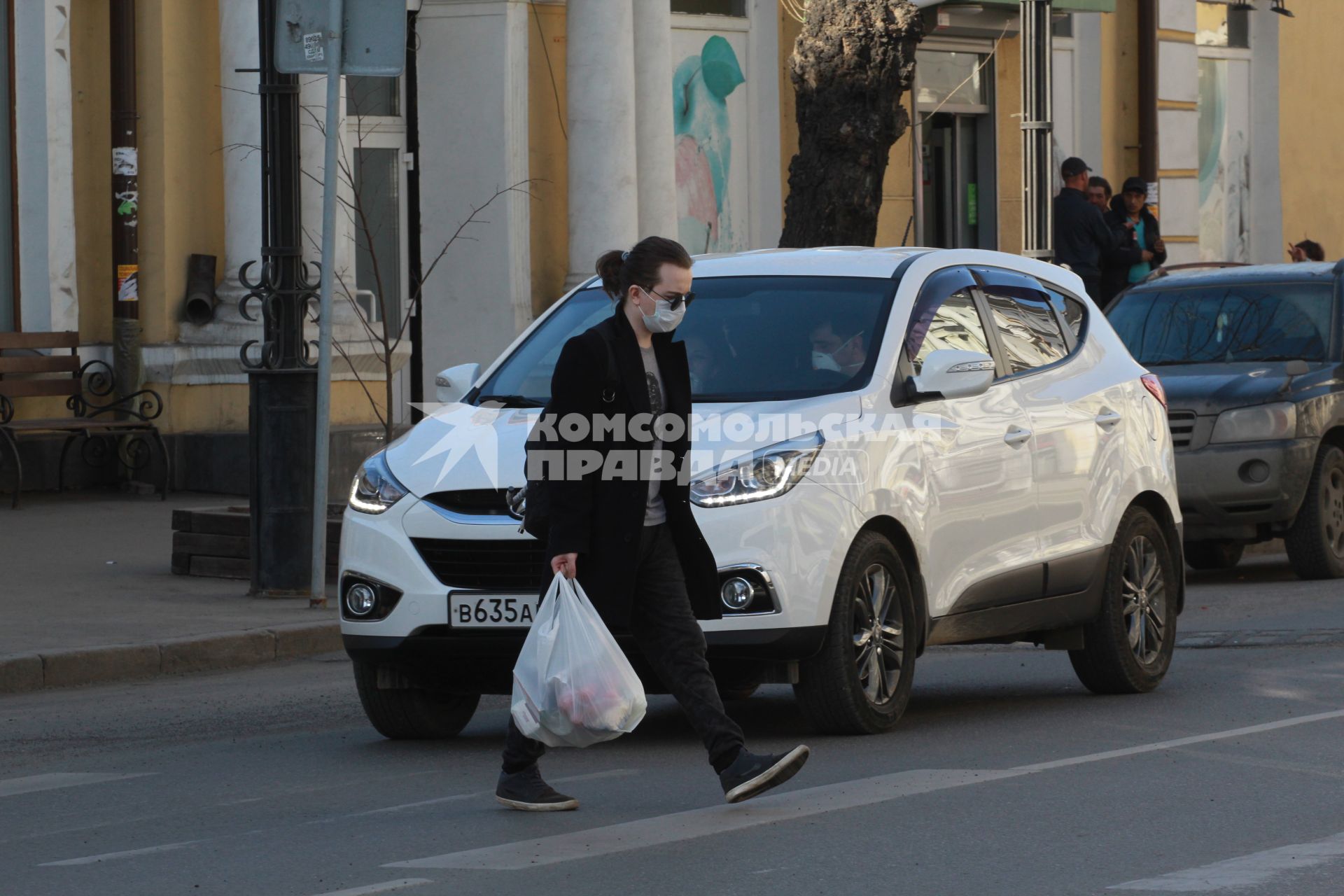 Иркутск. Мужчина в медицинской маске на улице города.