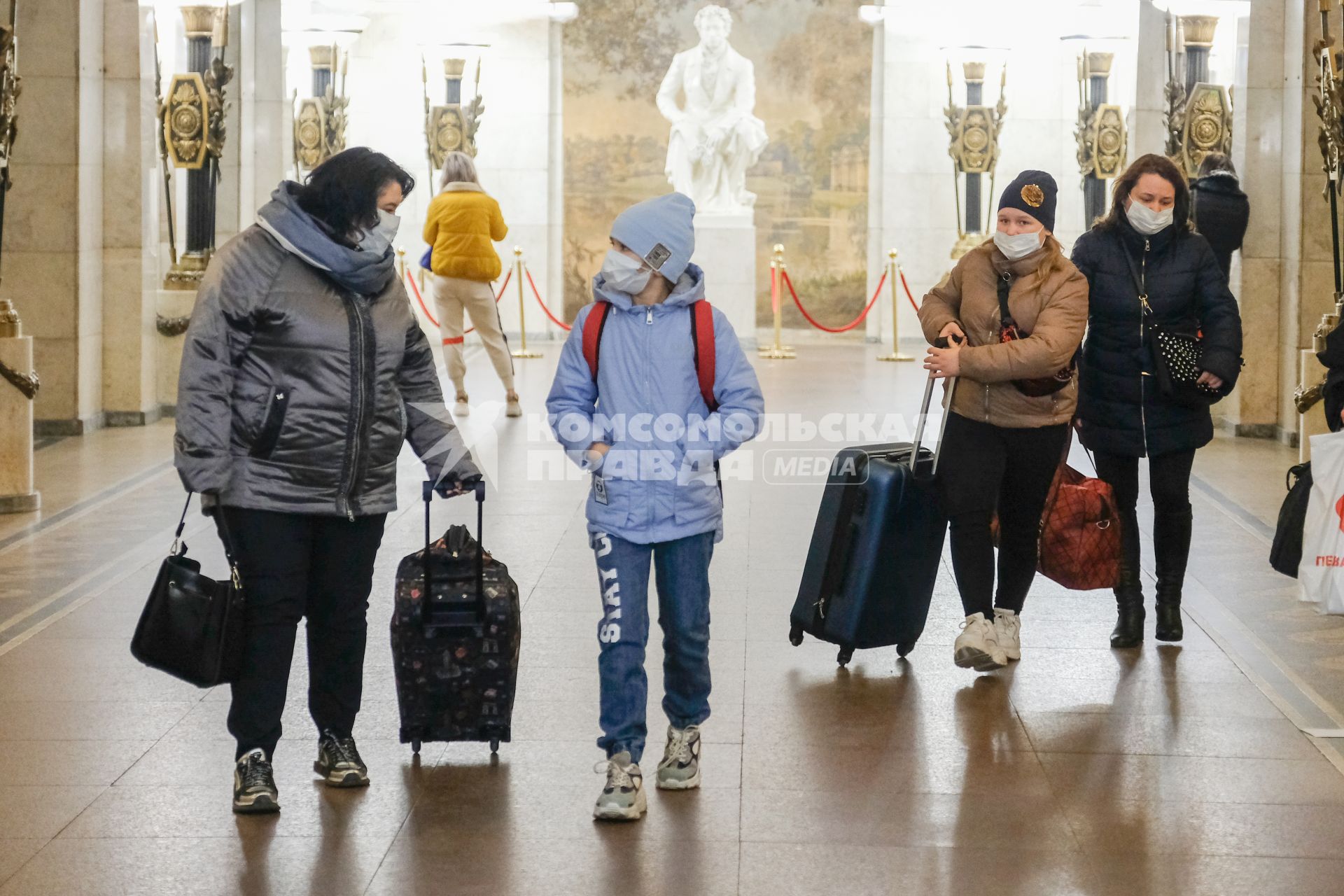 Санкт-Петербург. Пассажиры с чемоданами в медицинских масках на станции метро.