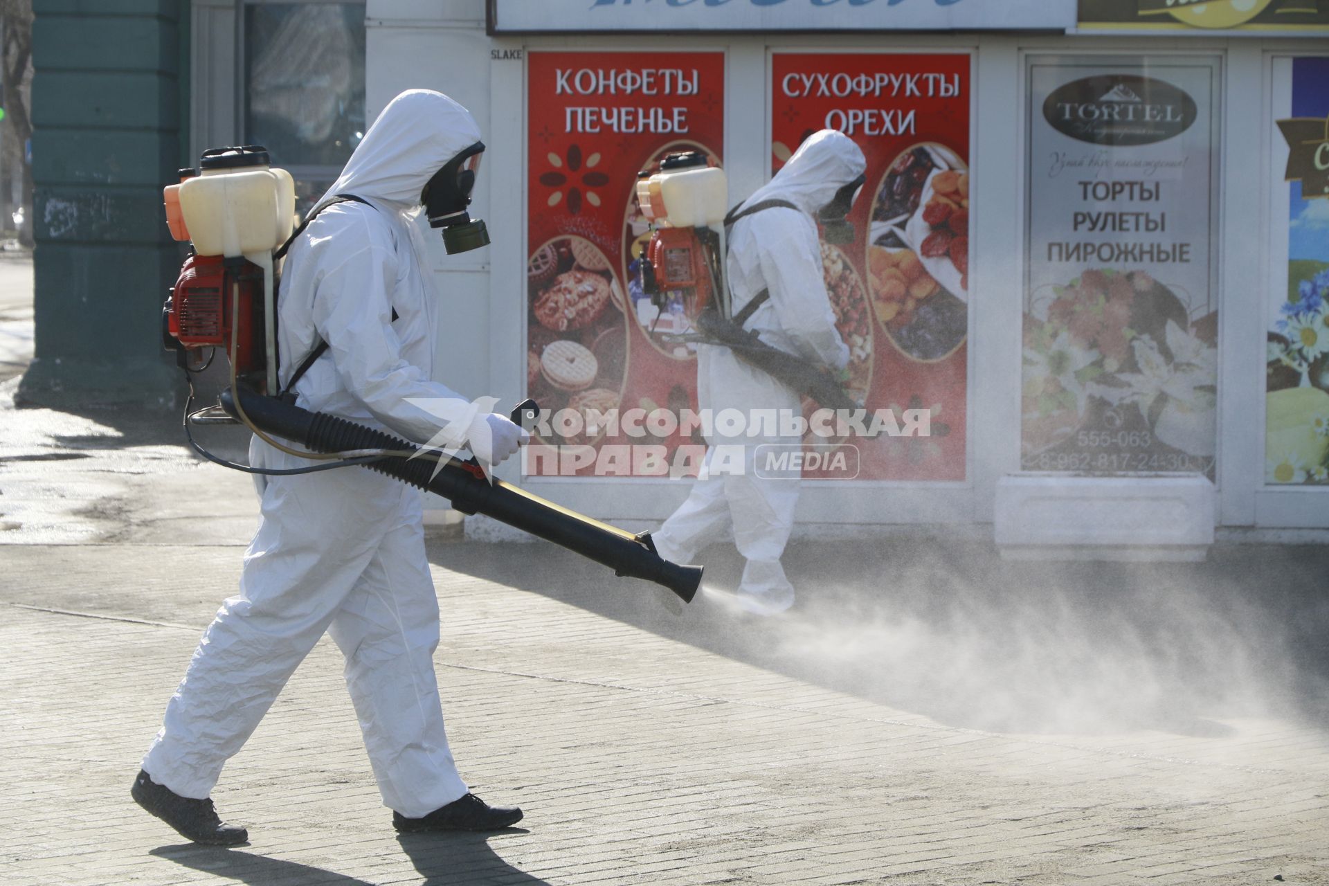 Барнаул. Сотрудник коммунальной службы в защитном костюме во время дезинфекции улиц.