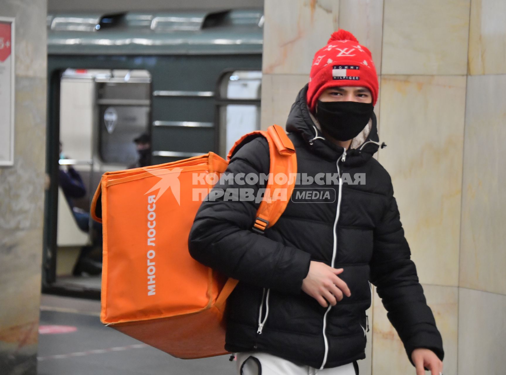 Москва. Сотрудник сервиса доставки еды в медицинской маске в метро.