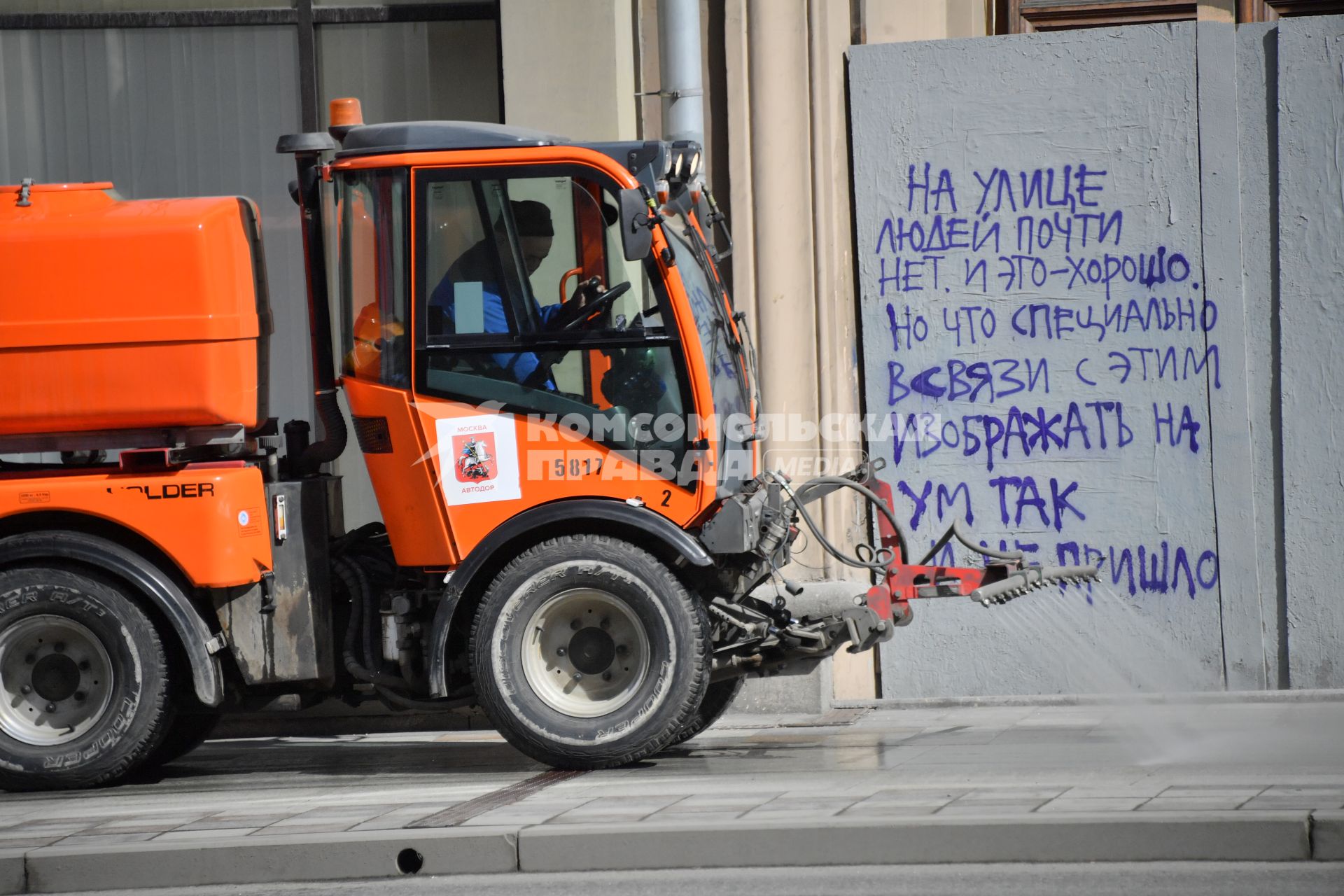 Москва.   Автомобиль коммунальной службы моет улицу.