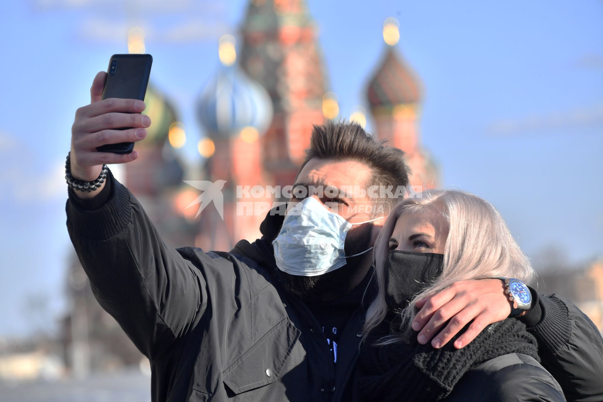 Москва. Молодой человек и девушка в медицинских масках фотографируются  на  Красной площади