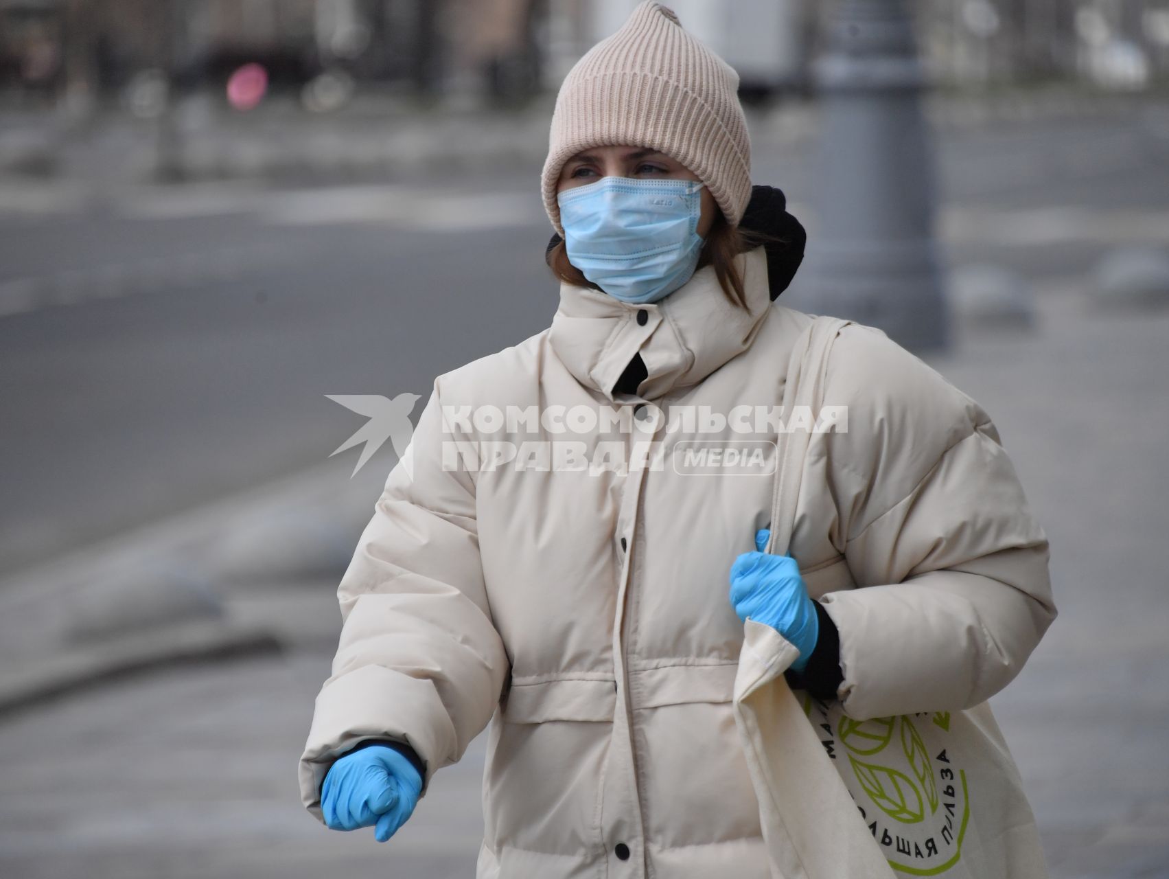 Москва. Женщина в медицинской маске и резиновых перчатках на улице.