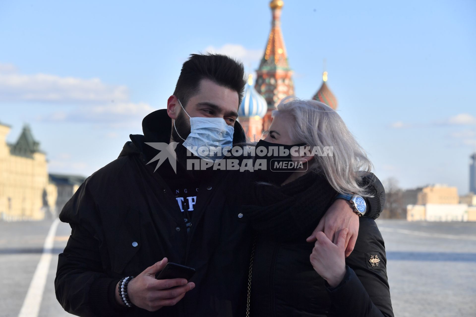 Москва. Молодой человек и девушка в медицинских масках фотографируются  на  Красной площади