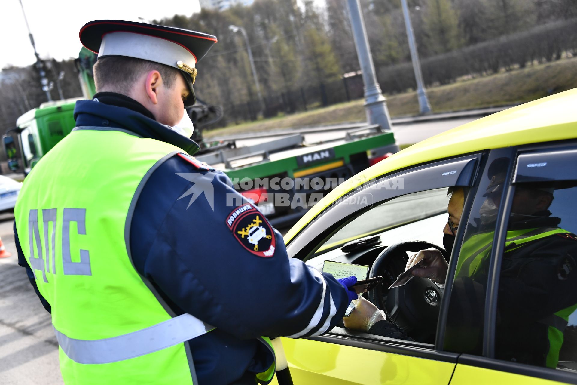 Москва. Сотрудник дорожно-патрульной службы ГИБДД во время проверки электронного пропуска у водителя на блокпосту при въезде в Москву.