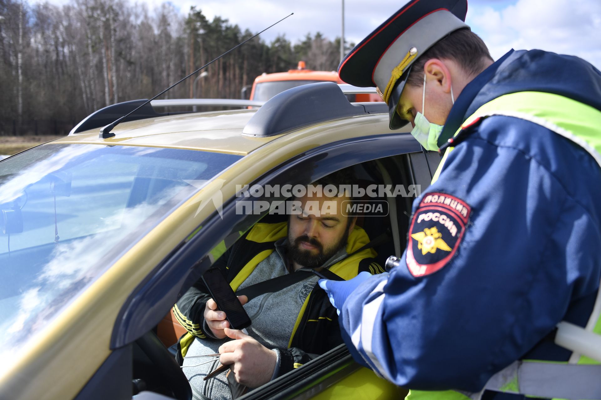 Москва. Сотрудник дорожно-патрульной службы ГИБДД во время проверки электронного пропуска у водителя на блокпосту при въезде в Москву.