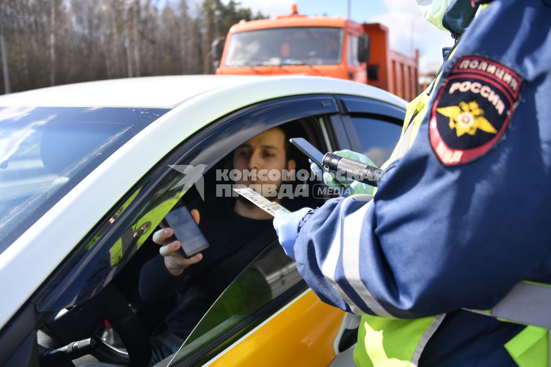 Москва. Сотрудник дорожно-патрульной службы ГИБДД во время проверки электронного пропуска у водителя на блокпосту при въезде в Москву.