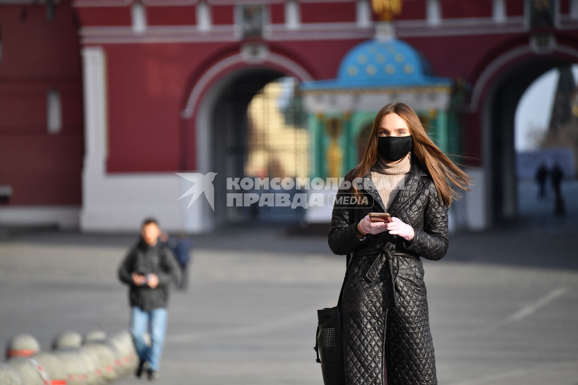 Москва. Девушка в защитной маске на Манежной площади.