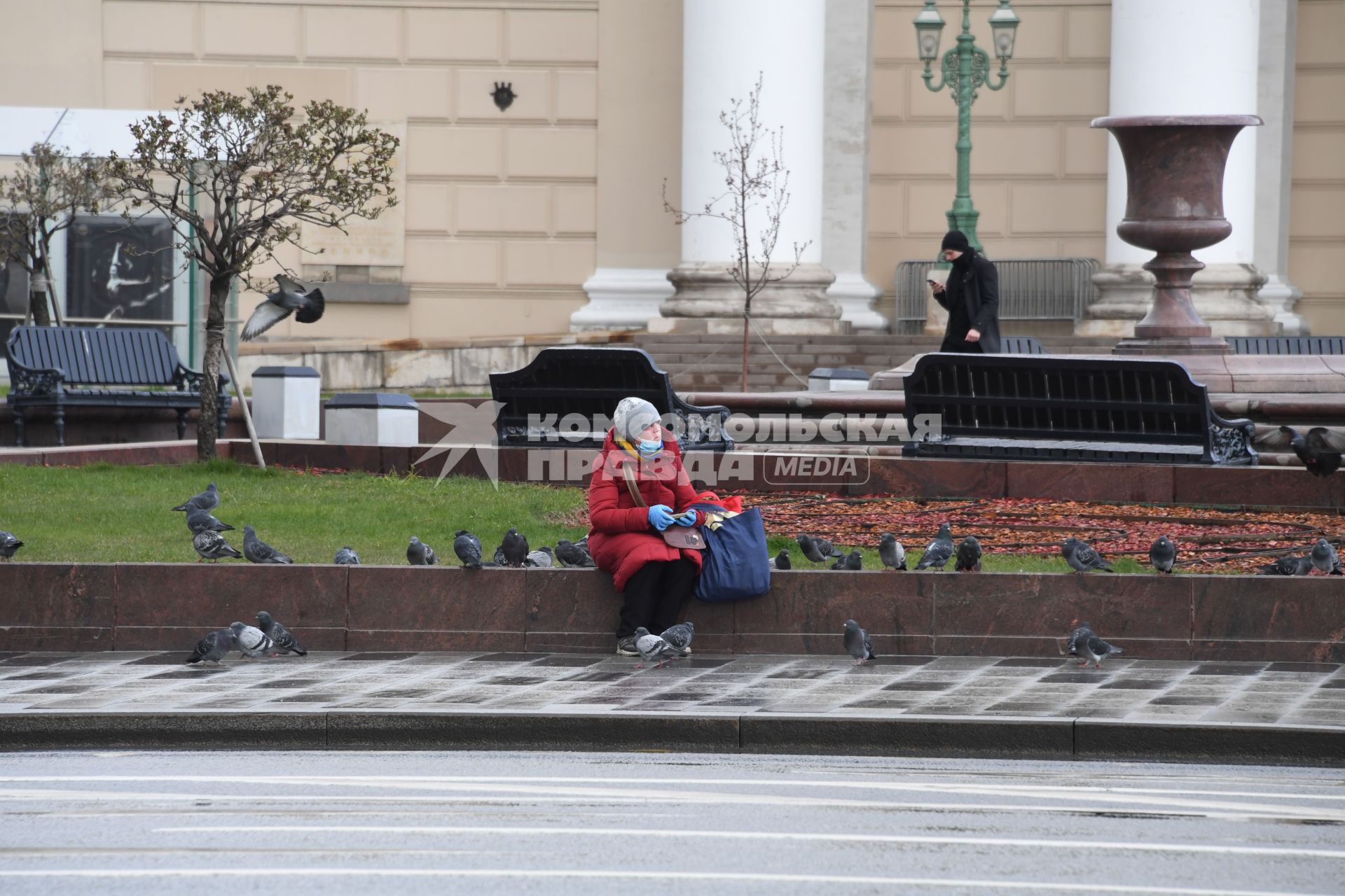 Москва.  Женщина в медицинской маске  у Большого Театра.