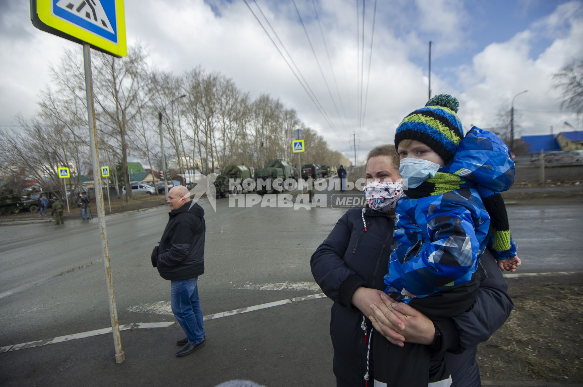 Екатеринбург. Женщина с ребенком в медицинских масках набдюдают за проведением репетиции парада.