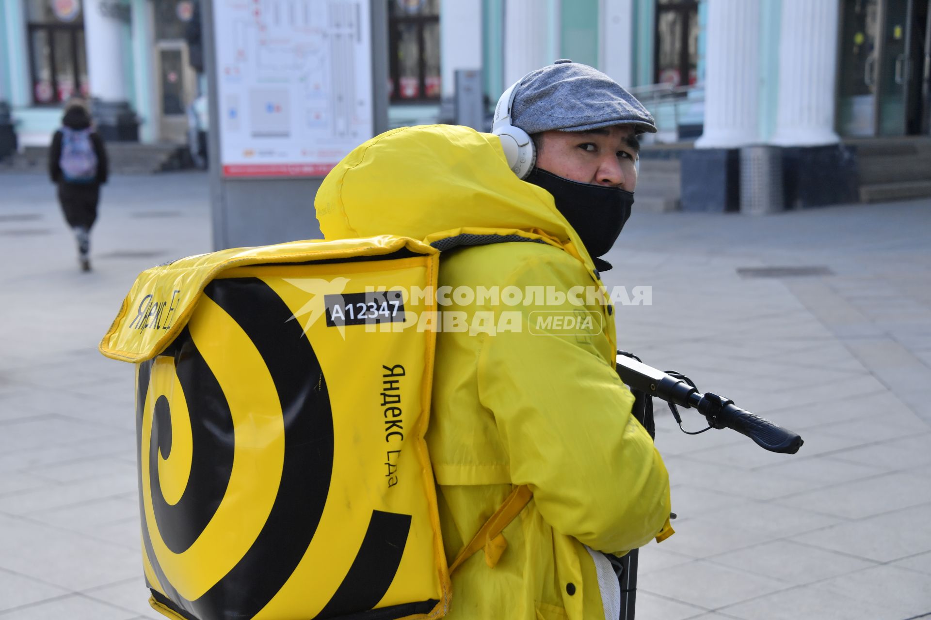 Москва. Сотрудник сервиса доставки еды в медицинской маске.