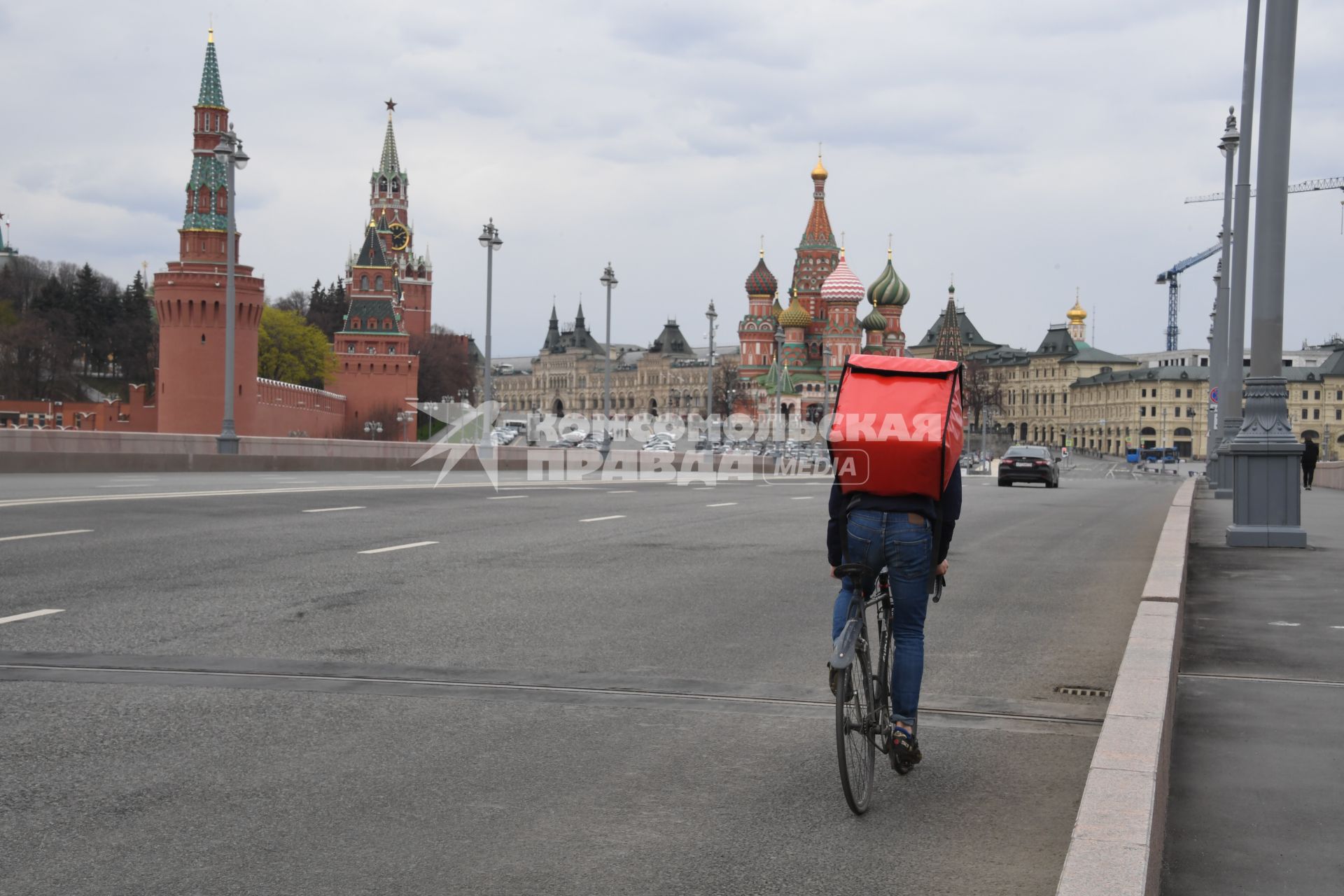 Москва.  Сотрудник сервиса доставки еды на Большом Москворецком мосту.