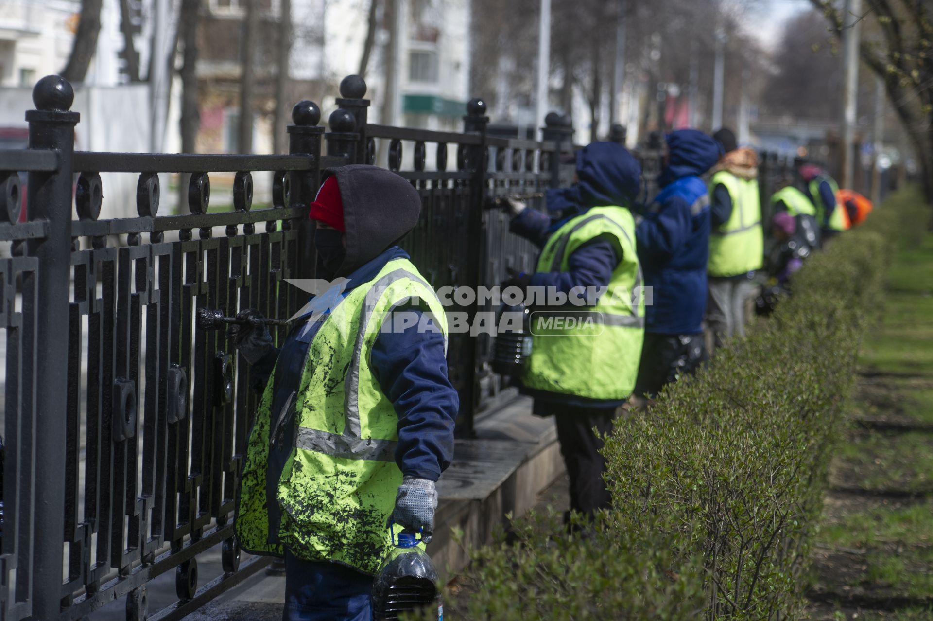 Екатеринбург. Рабочие службы городского благоустройства красят ограждение на улице