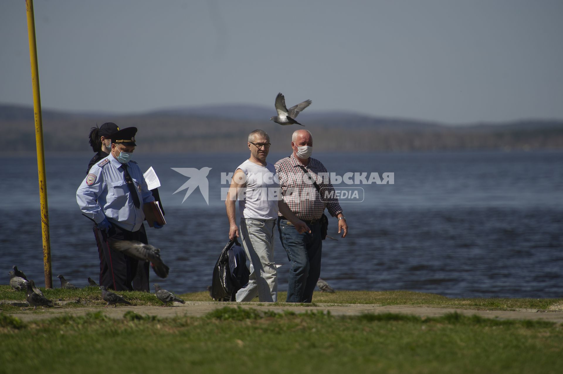 Екатеринбург. Сотрудники полиции сопровождают мужчину задержаного на пляже, за нарушение режима самоизоляции введеного для нераспространения новой коронавирусной инфекции COVID-19