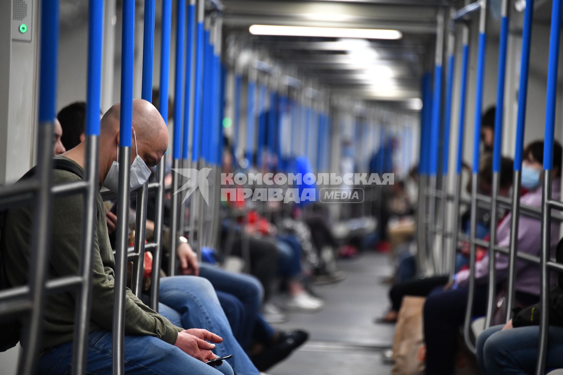 Москва. Пассажиры в медицинских масках в вагоне поезда метро.