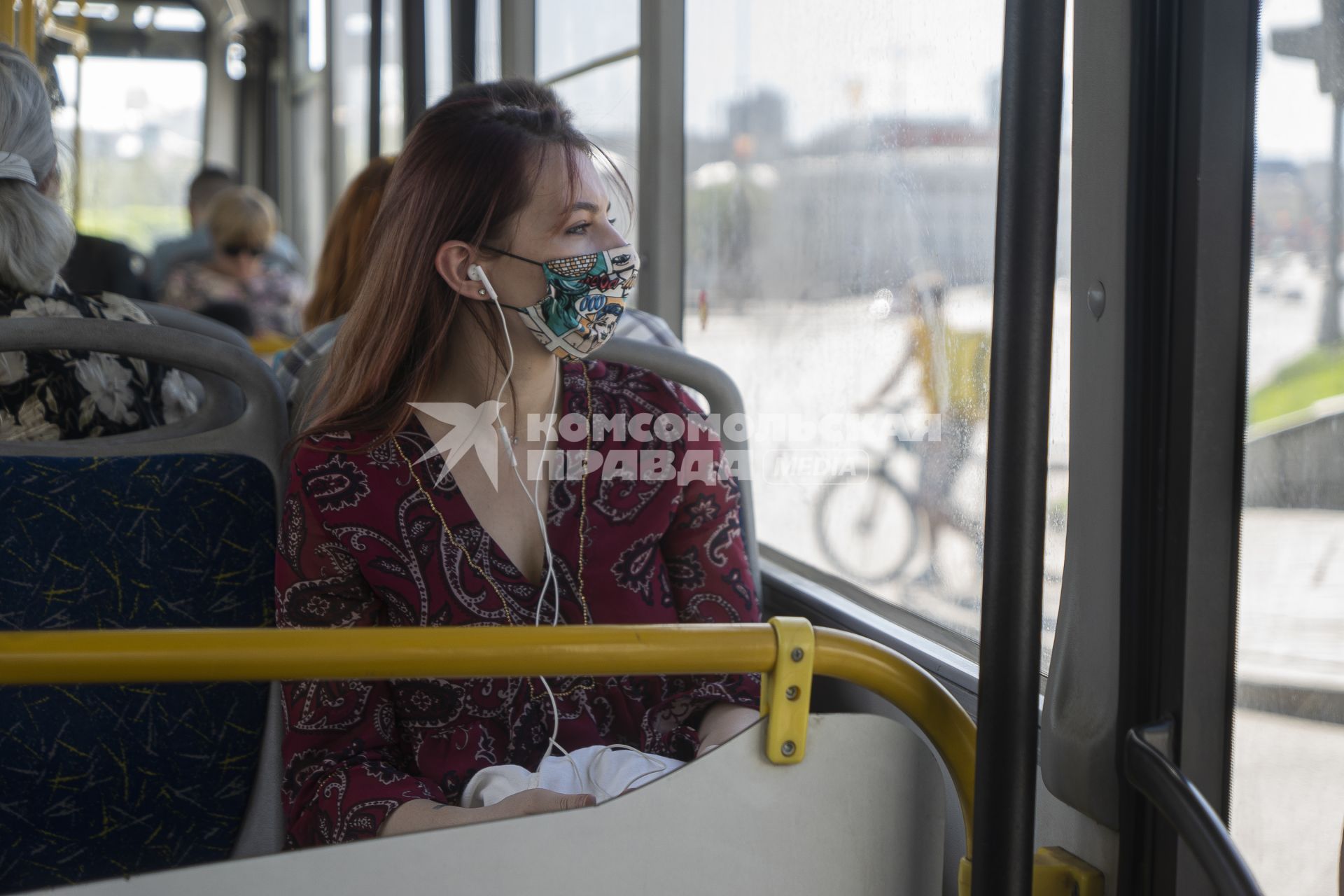 Екатеринбург. Девушка в защитной маске в автобусе. В Свердловской области с 1 мая 2020г введен \'Масочный режим\', когда в общественном транспорте и замкнутых пемещениях обязательно находиться в медицинской или защитной маске. Режим самоизоляции для нераспространения новой коронавирусной инфекции COVID-19