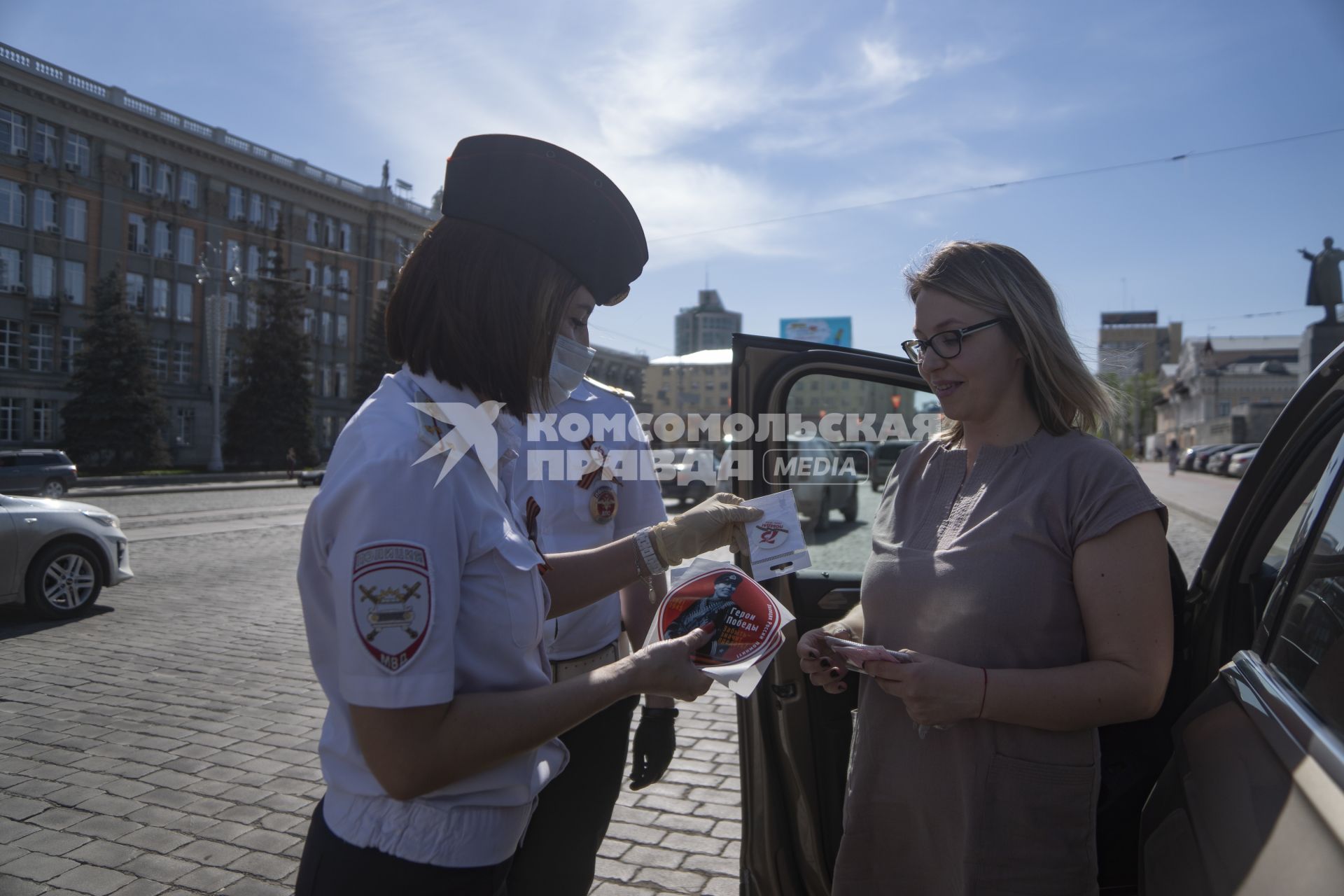 Екатеринбург. Сотрудники ГИБДД вручают водителю светоотражающие значки  наклейки с символикой 75-й годовщины Победы, накануне Дня Победы