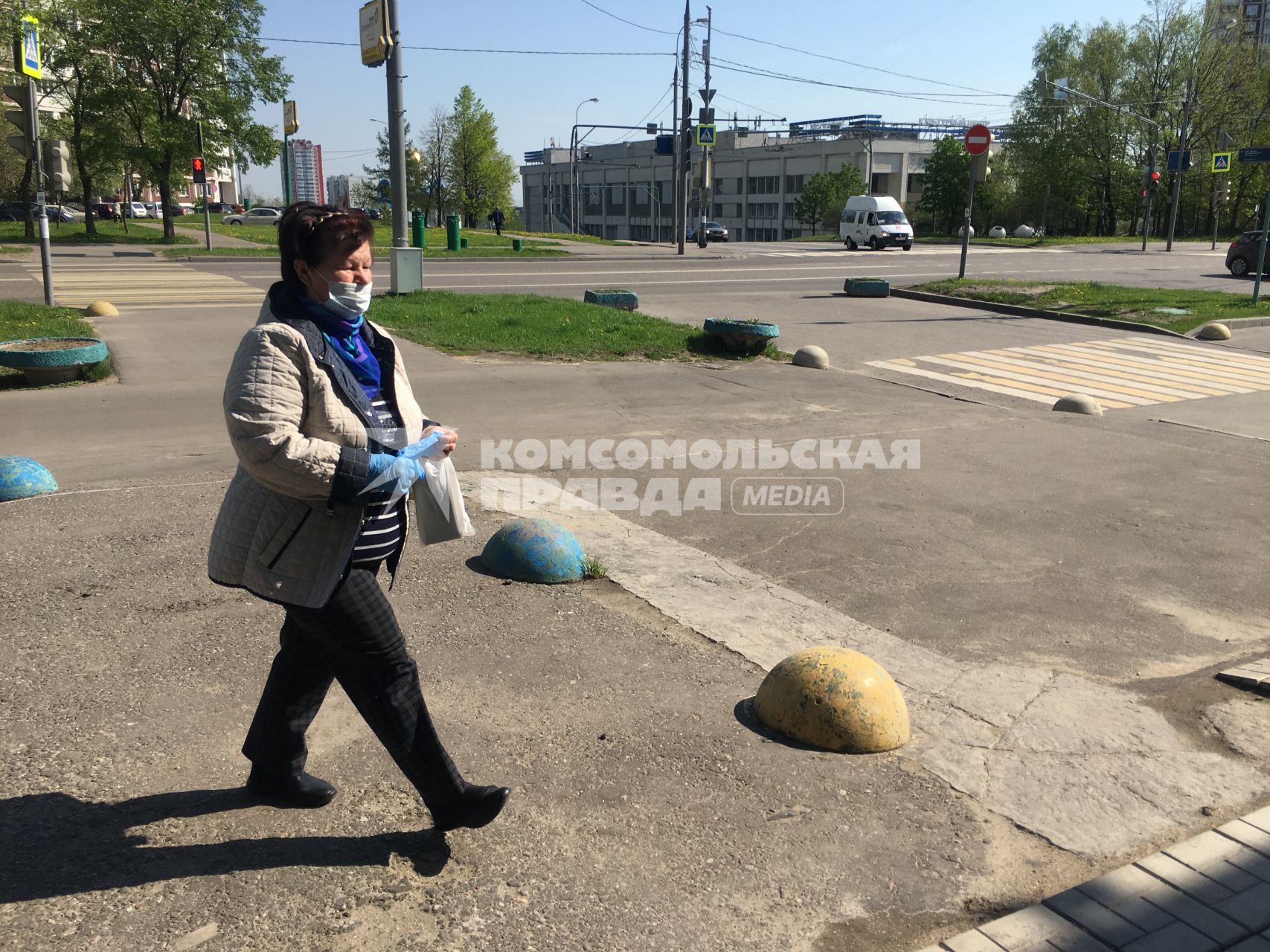 Москва. Женщина в медицинской маске и перчатках на улице города.