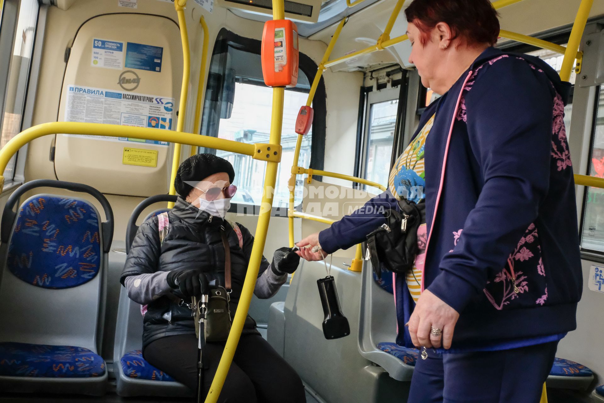 Санкт-Петербург.  Пожилая женщина в медицинской маске в автобусе.
