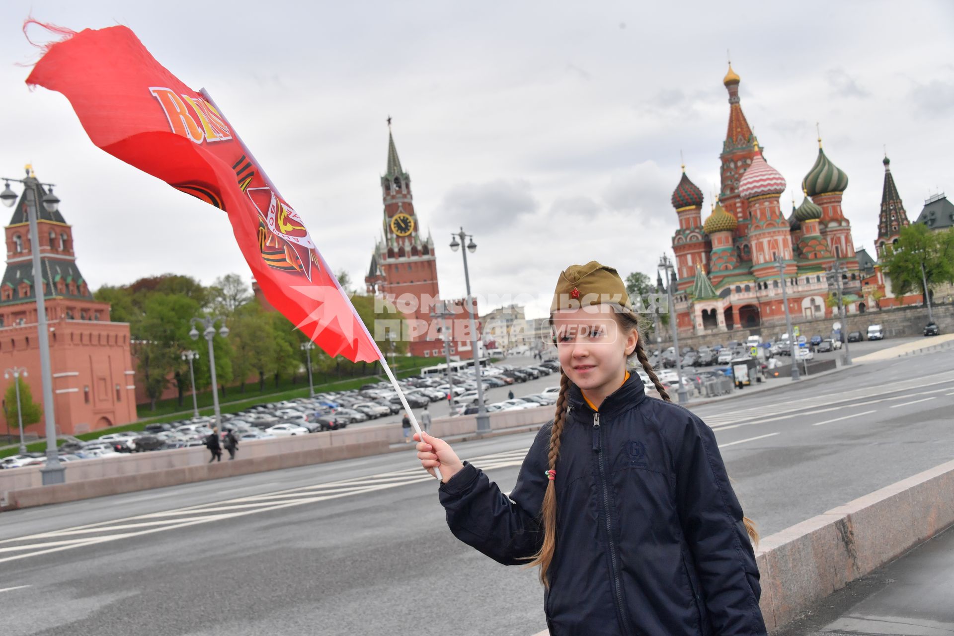 Москва. Девочка с красным флагом и  военной пилотке  на Васильевском спуске  во время воздушного парада Победы в Москве.