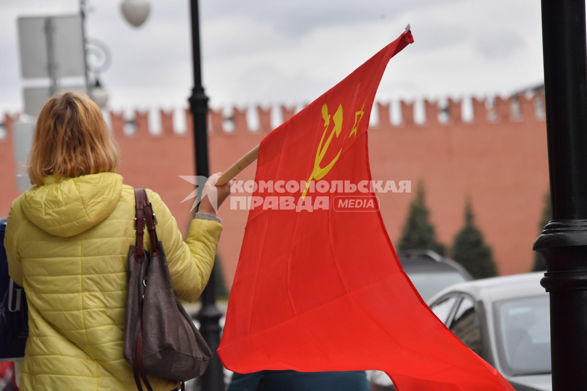 Москва.  Женщина с красным флагом на Красной площади во время празднования Дня Победы.