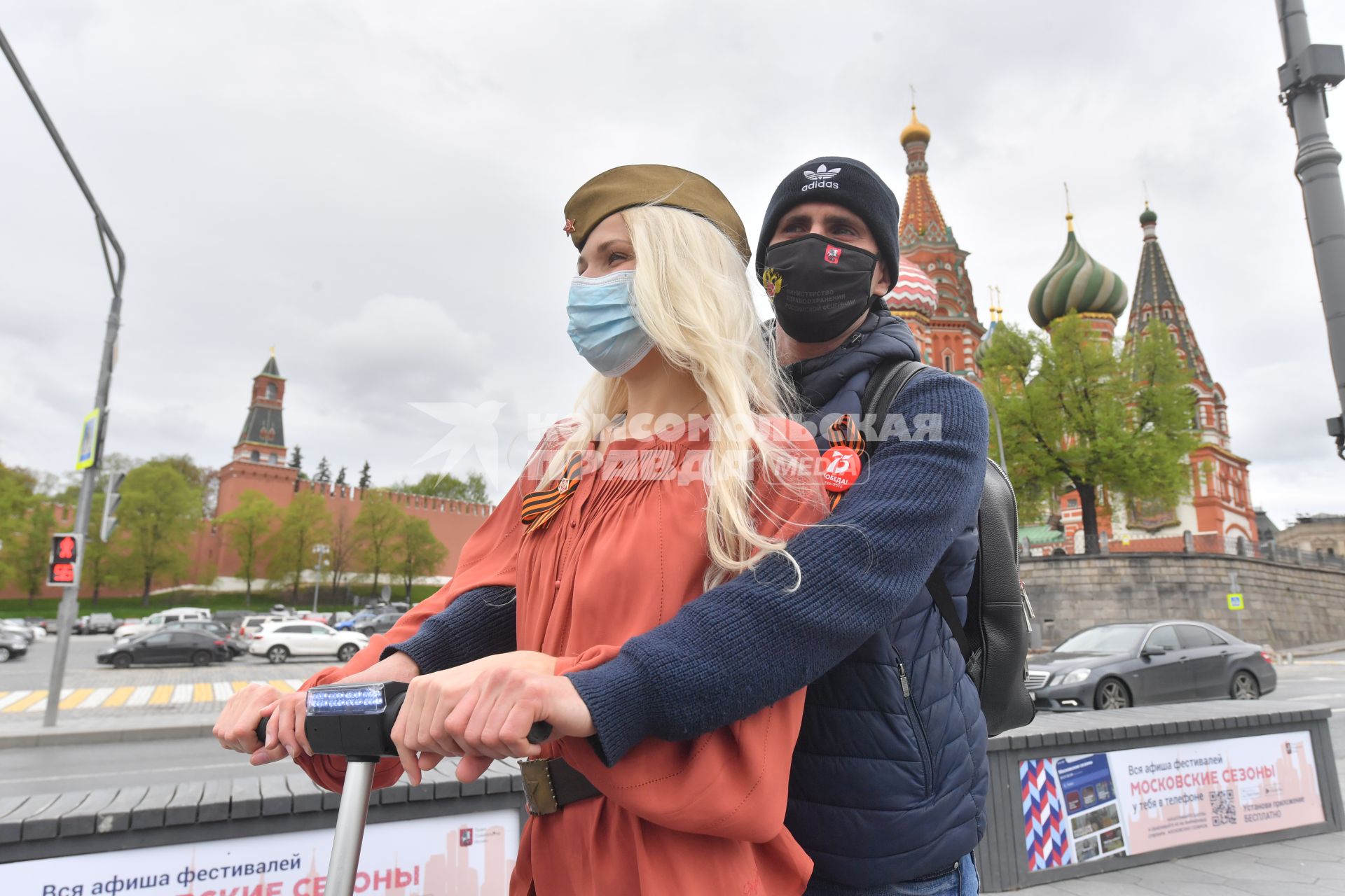 Москва.  Молодые люди в медицинских масках на Красной площади во время празднования Дня Победы.