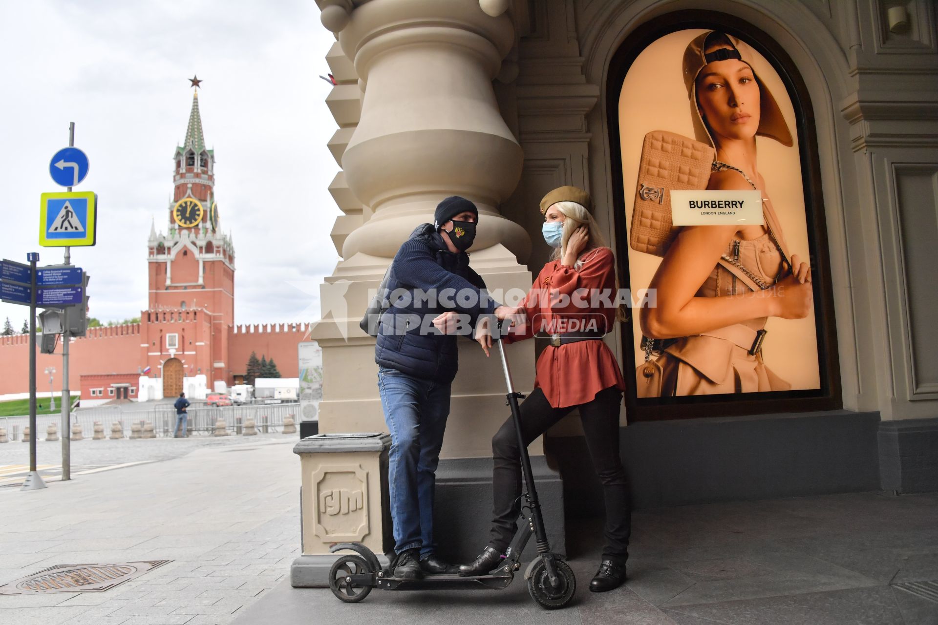 Москва.  Молодые люди в медицинских масках на Красной площади во время празднования Дня Победы.