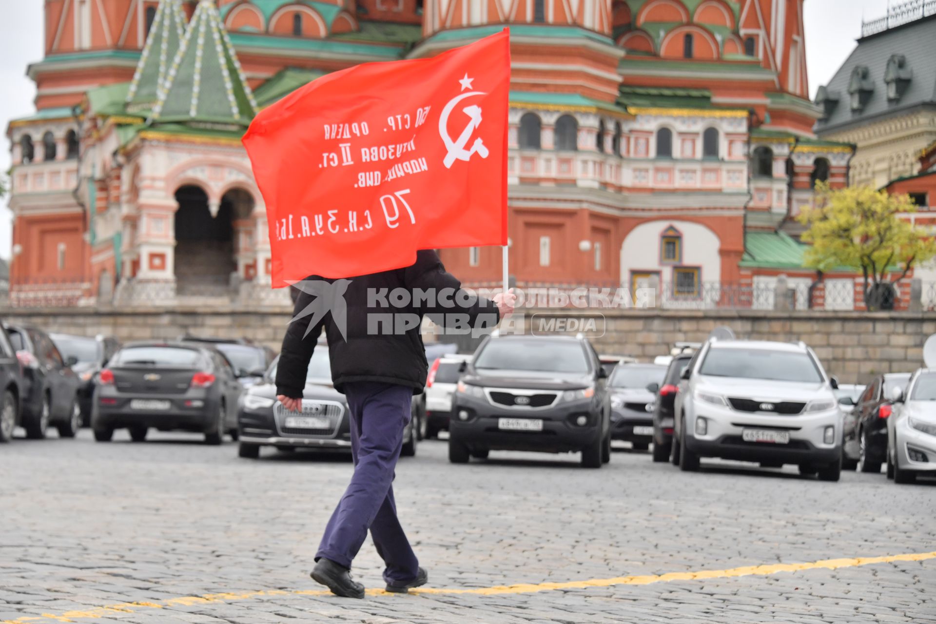 Москва.  Мужчина с красным флагом на Васильевском спуске во время празднования дня Победы.