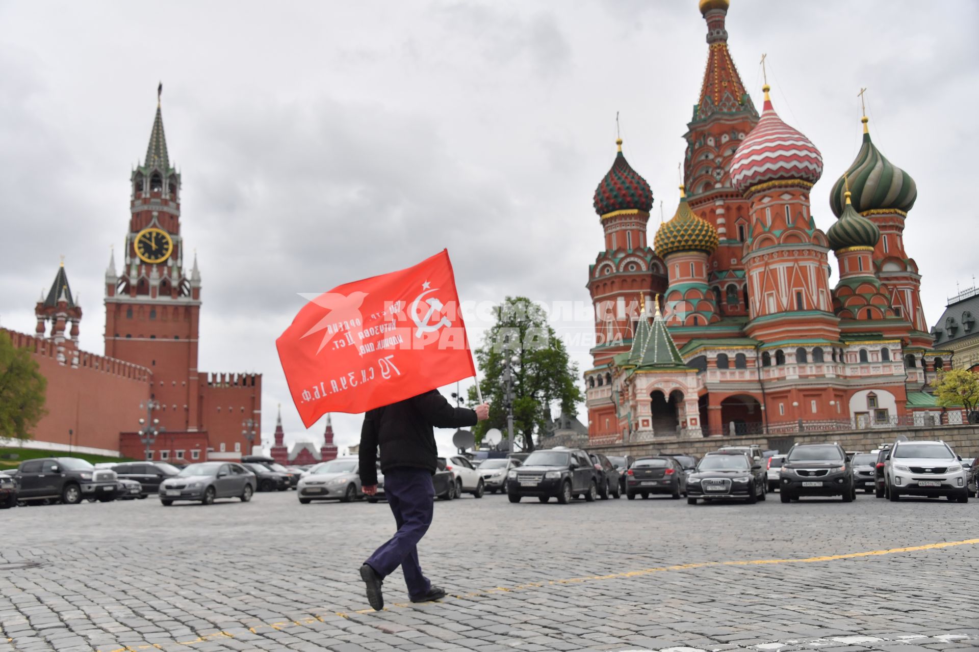 Москва.  Мужчина с красным флагом на Васильевском спуске во время празднования дня Победы.