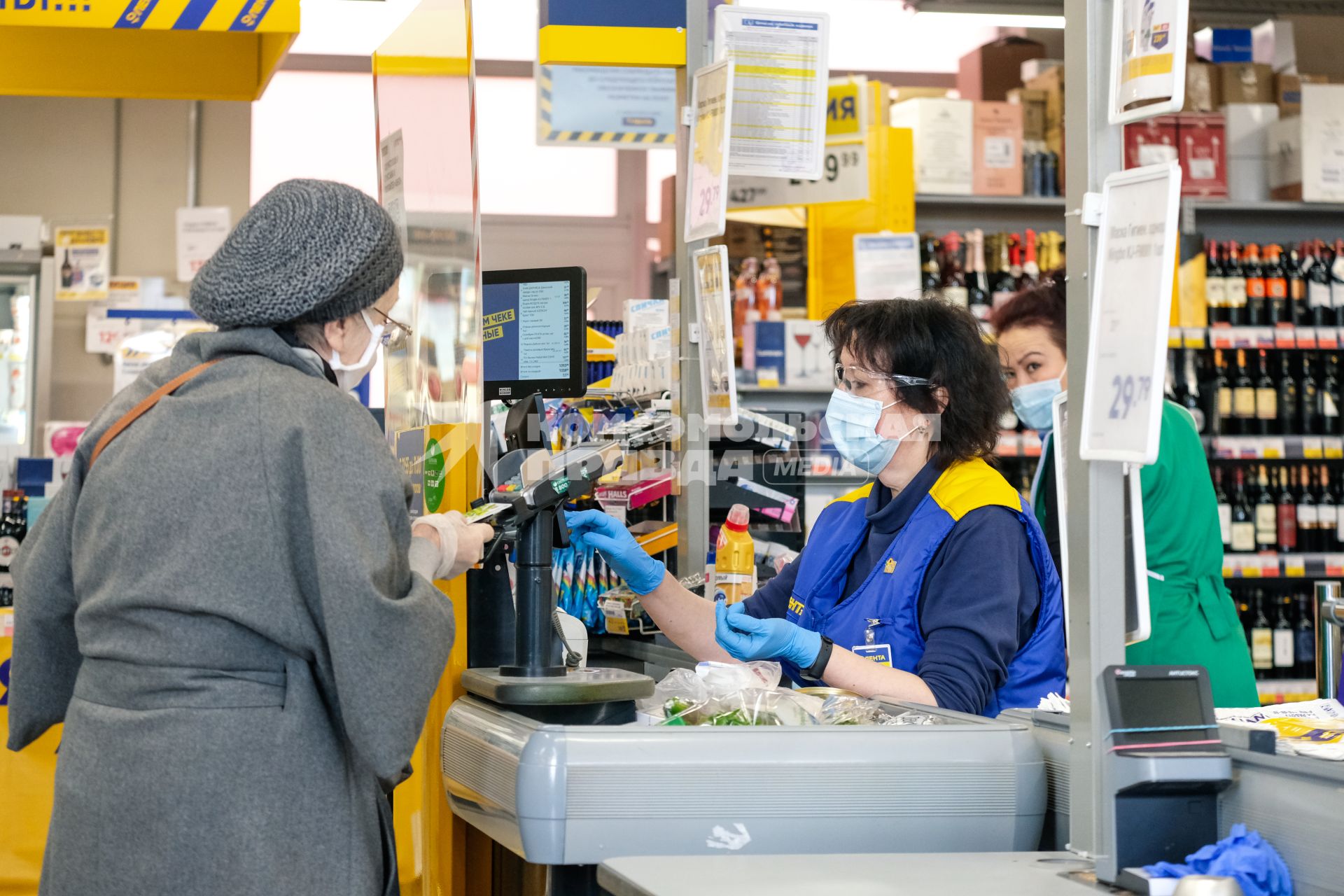 Санкт-Петербург. Покупатели и кассир в медицинской маске  в торговом зале магазина.